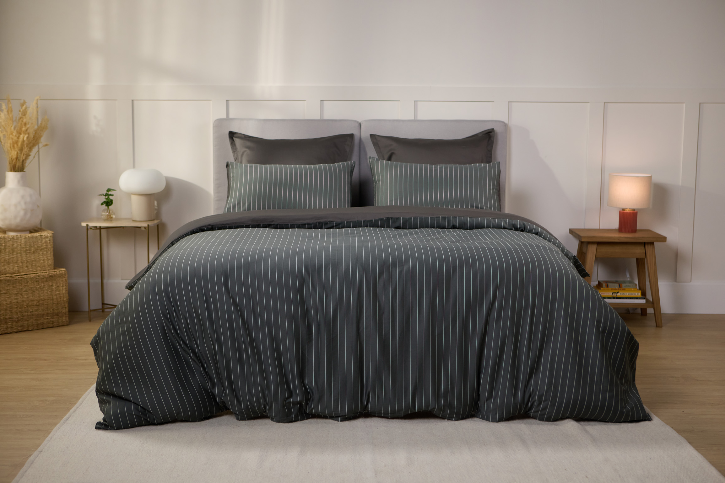 Vue de face d’une chambre décorée, avec un lit doté d’une couette colorée et de taies d’oreiller.