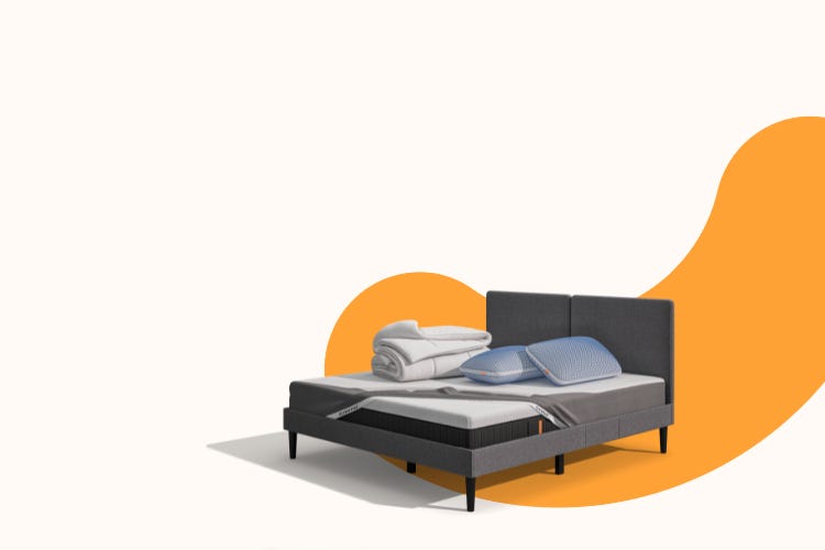 Lit moderne avec tête de lit grise et pieds noirs, recouvert de draps blancs. Deux oreillers blancs et une pile de linge plié sont posés sur le matelas. Arrière-plan beige avec une forme orange abstraite.