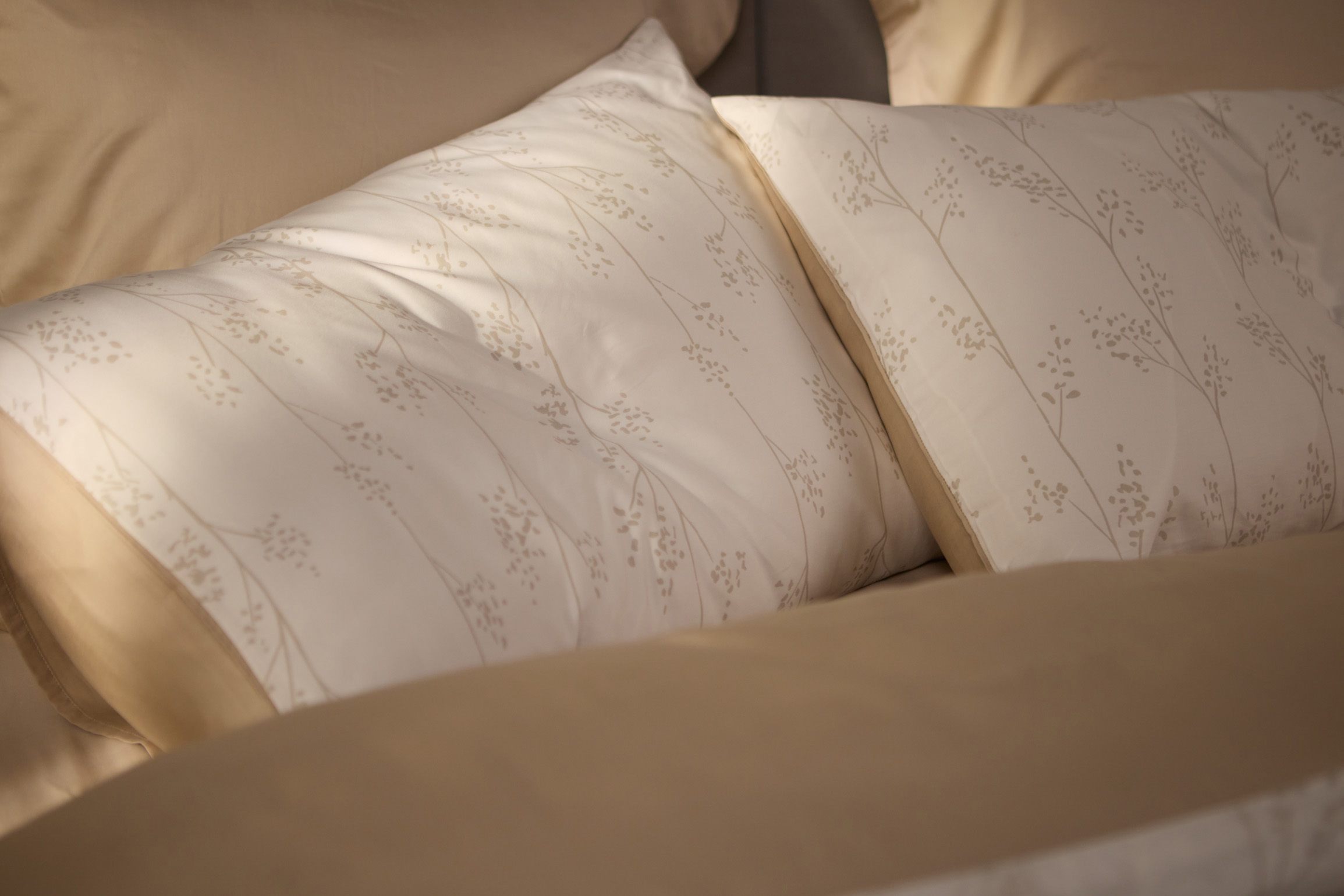 Bett mit weißer Bettdecke und Kissen.