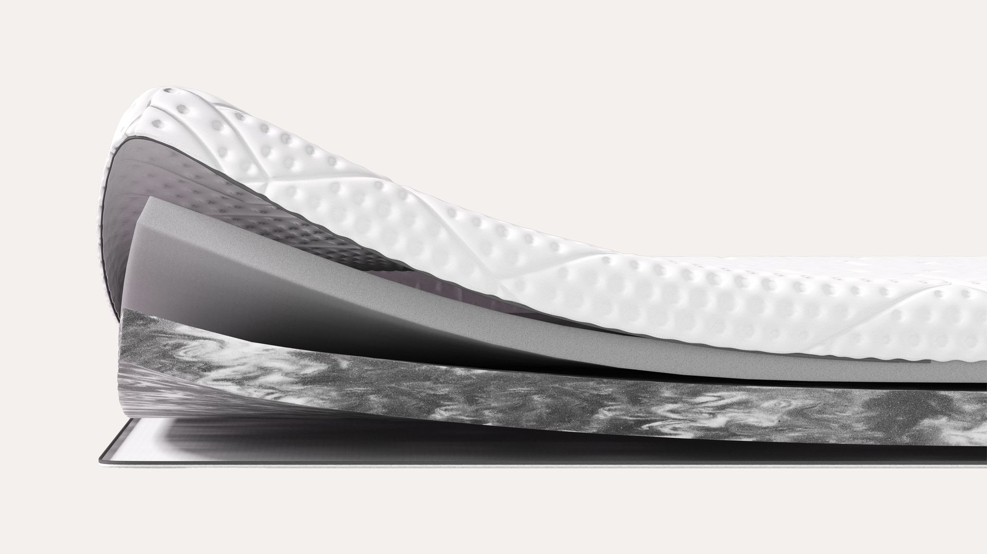 Sezione di un topper multistrato con superficie trapuntata bianca e vari strati in schiuma di diversi colori