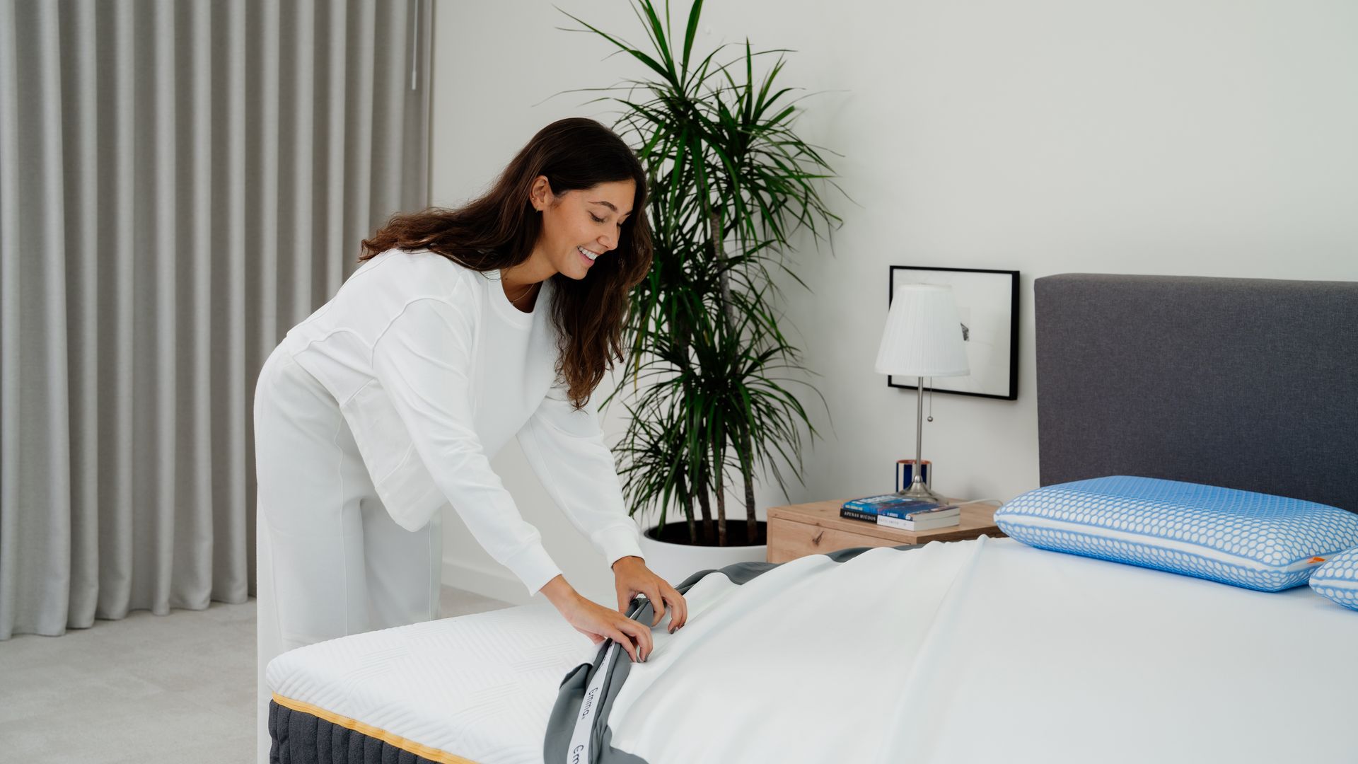 Una chica colocando un protector en su colchón.