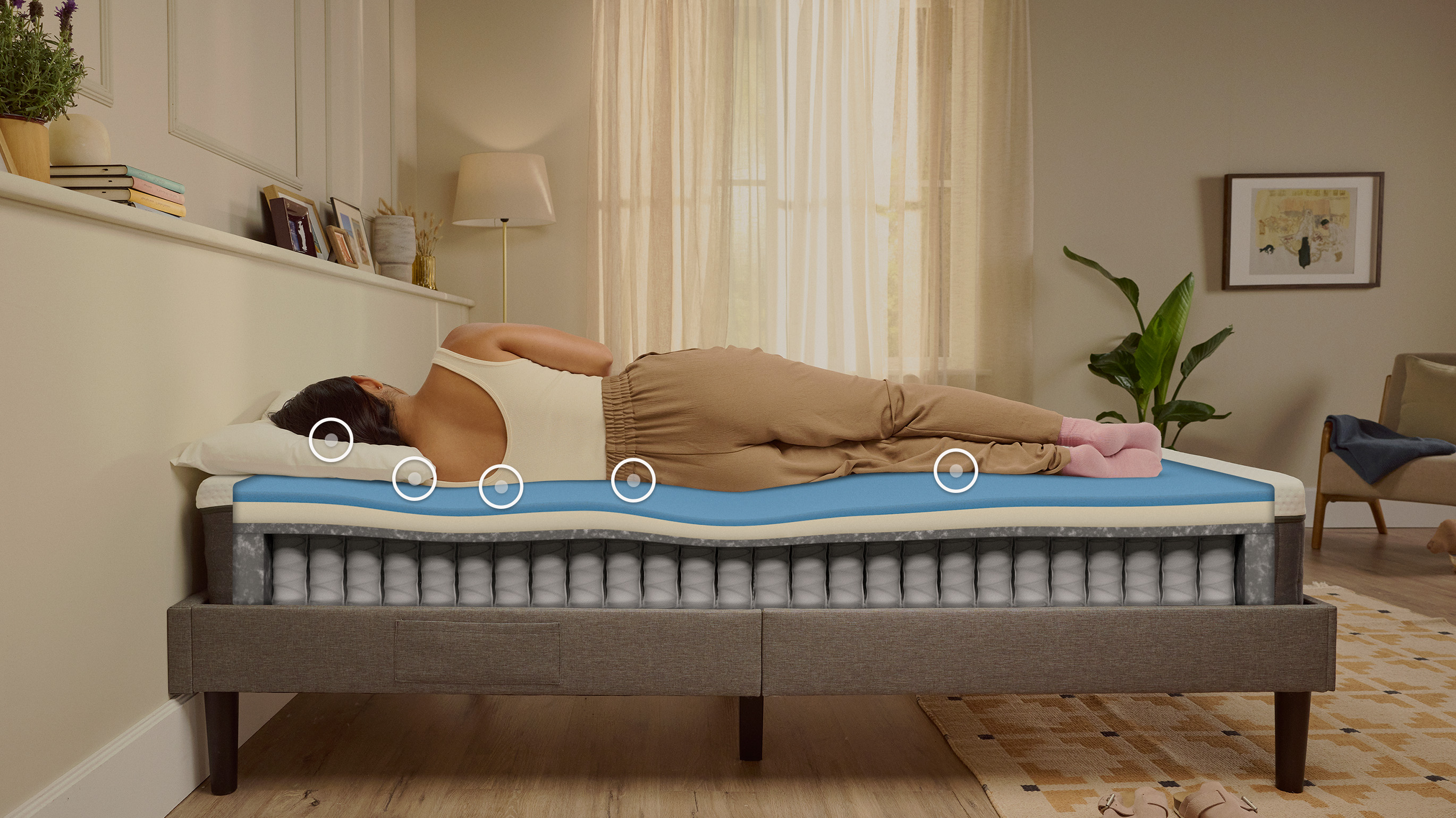 Woman sleeping on her side on an Emma Original mattress with a layers view showing foam and spring construction beneath her.
