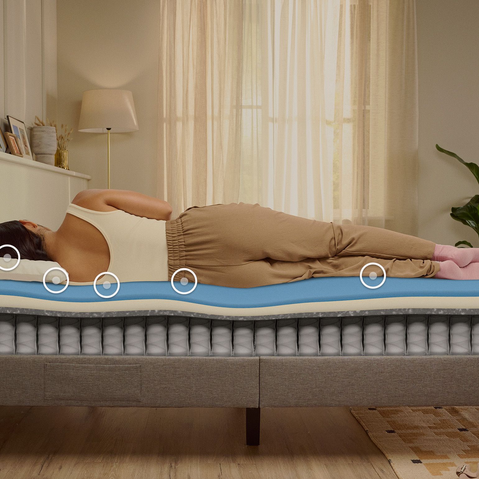 Une femme endormie sur le côté sur un matelas Emma Original, avec une vue en coupe montrant la structure en mousse et à ressorts sous elle.