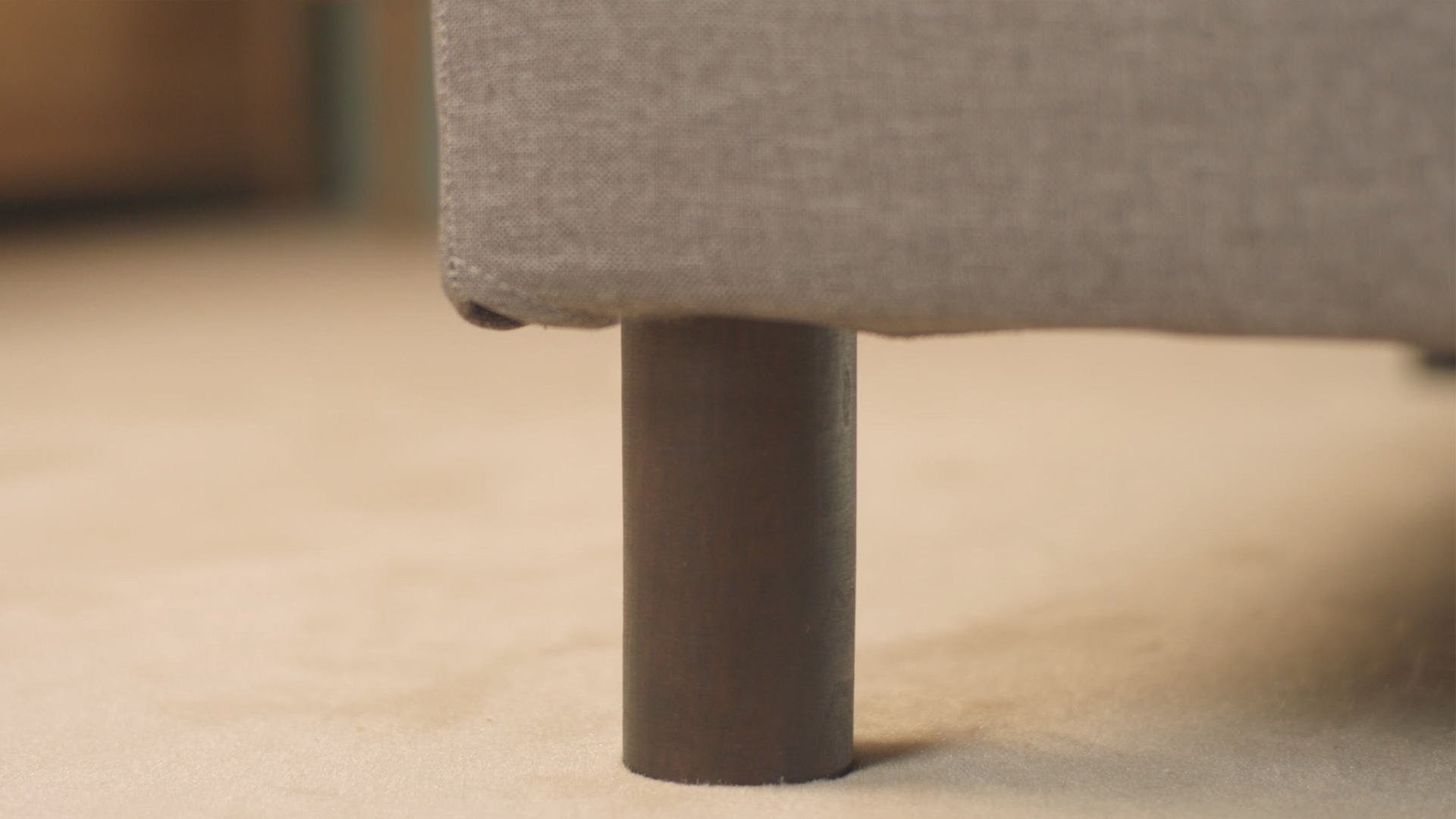 Gros plan sur le pied en bois et le cadre latéral du boxspring Caméléon