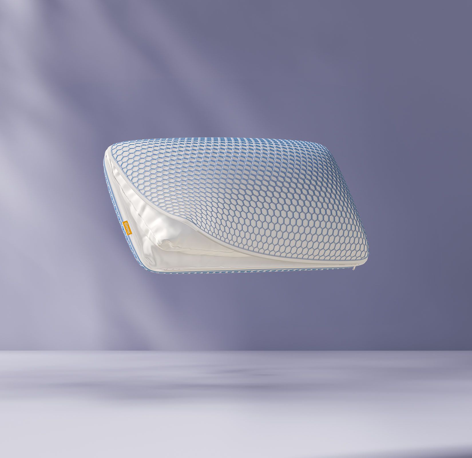 Oreiller flottant avec une grille en forme de nid d’abeille bleue, partiellement ouvert pour révéler le tissu intérieur, sur un fond violet clair.