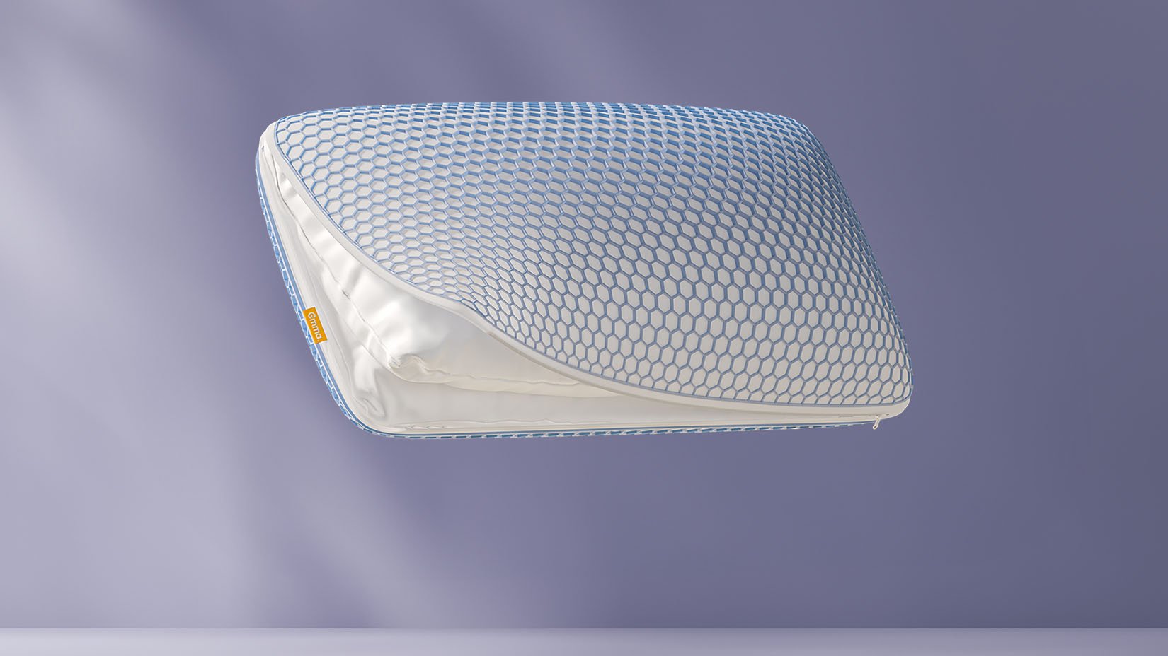 Oreiller flottant avec une grille en forme de nid d’abeille bleue, partiellement ouvert pour révéler le tissu intérieur, sur un fond violet clair.