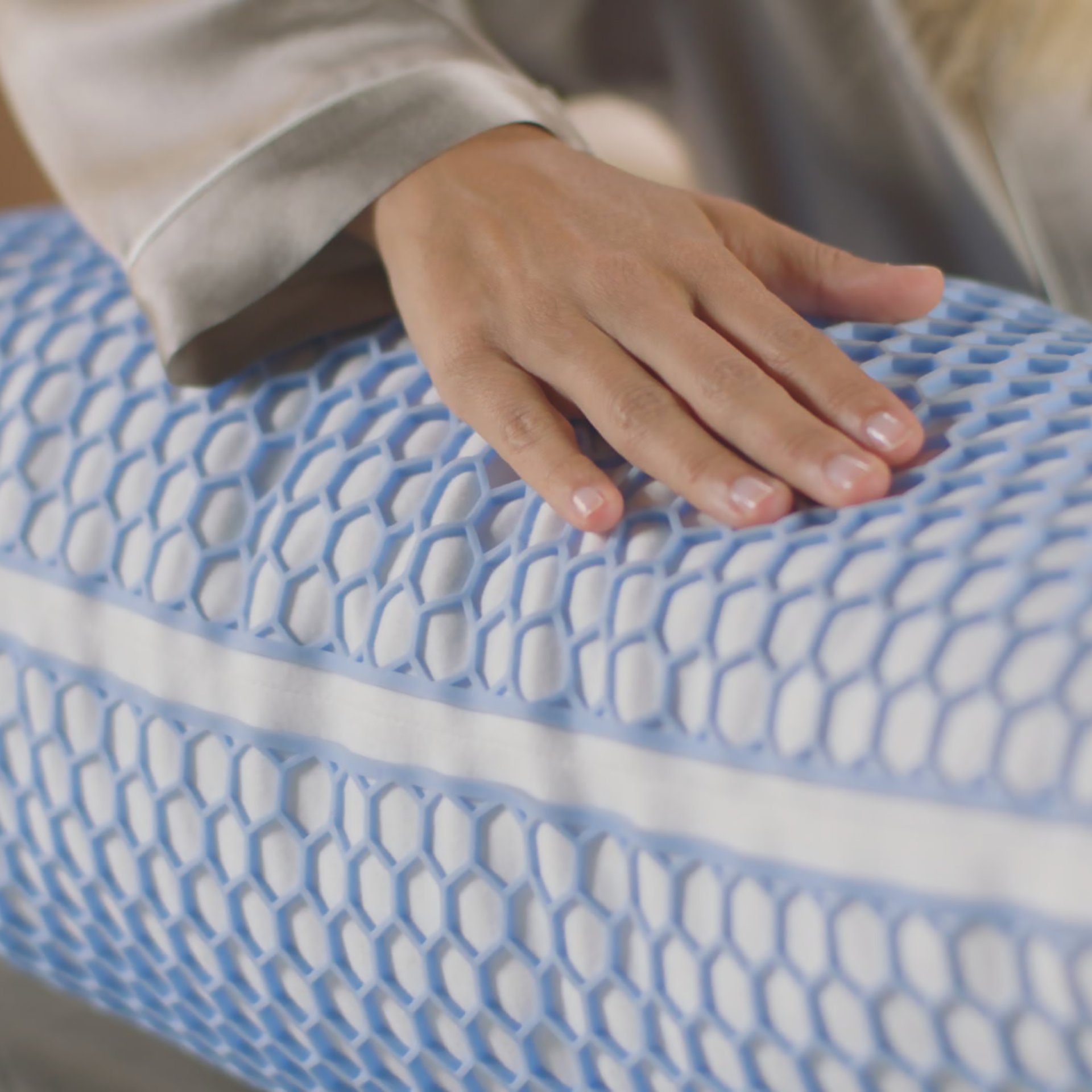 Descubre la Almohada Elite Microfiber con Funda Gel Grid y capas intercambiables. En la imagen, una mano tocando la almohada destaca su suavidad y calidad. Perfecta para un sueño reparador y personalizado.