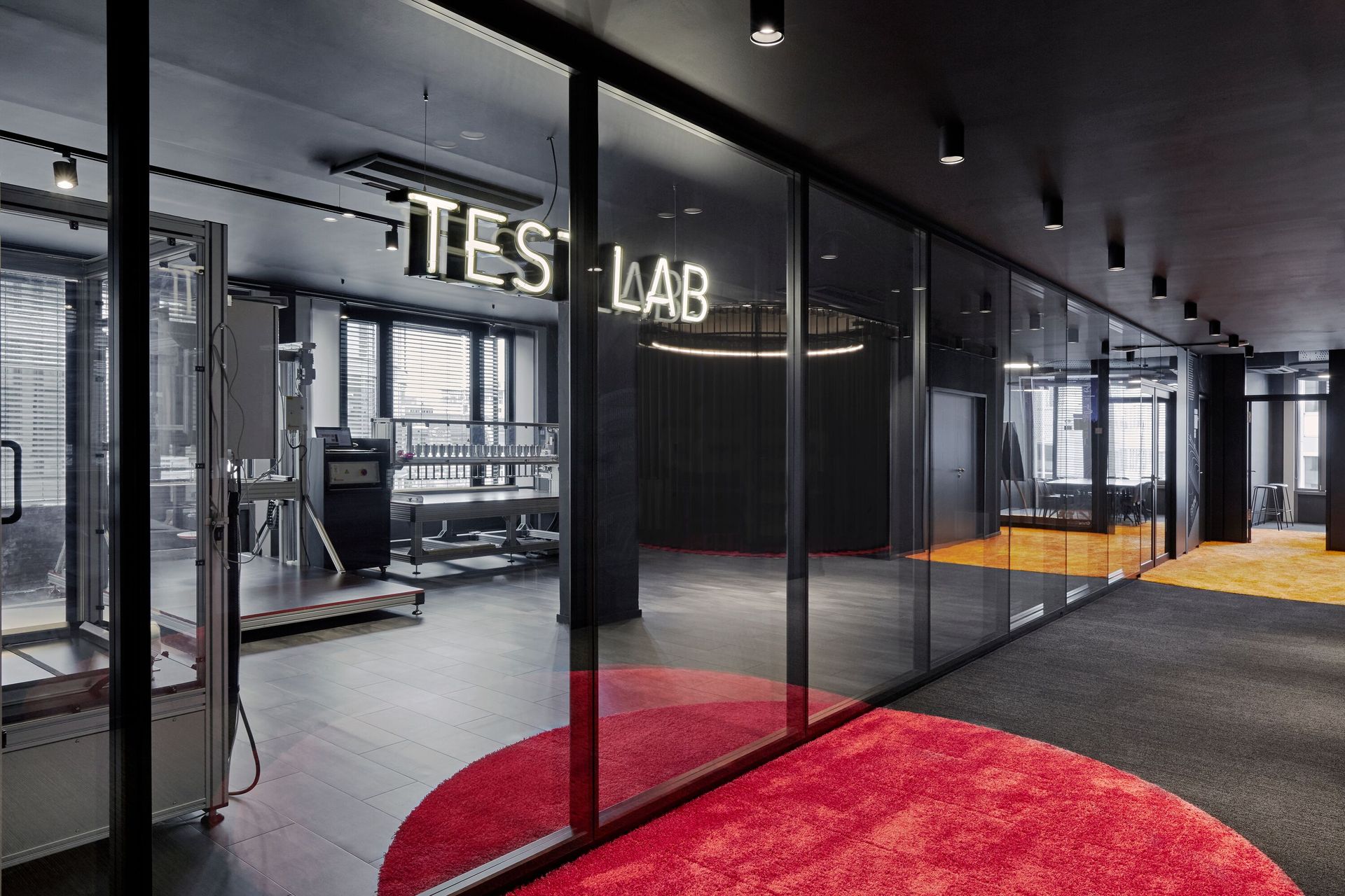 Emma Testlabor mit Glaswänden und roten Teppichen.