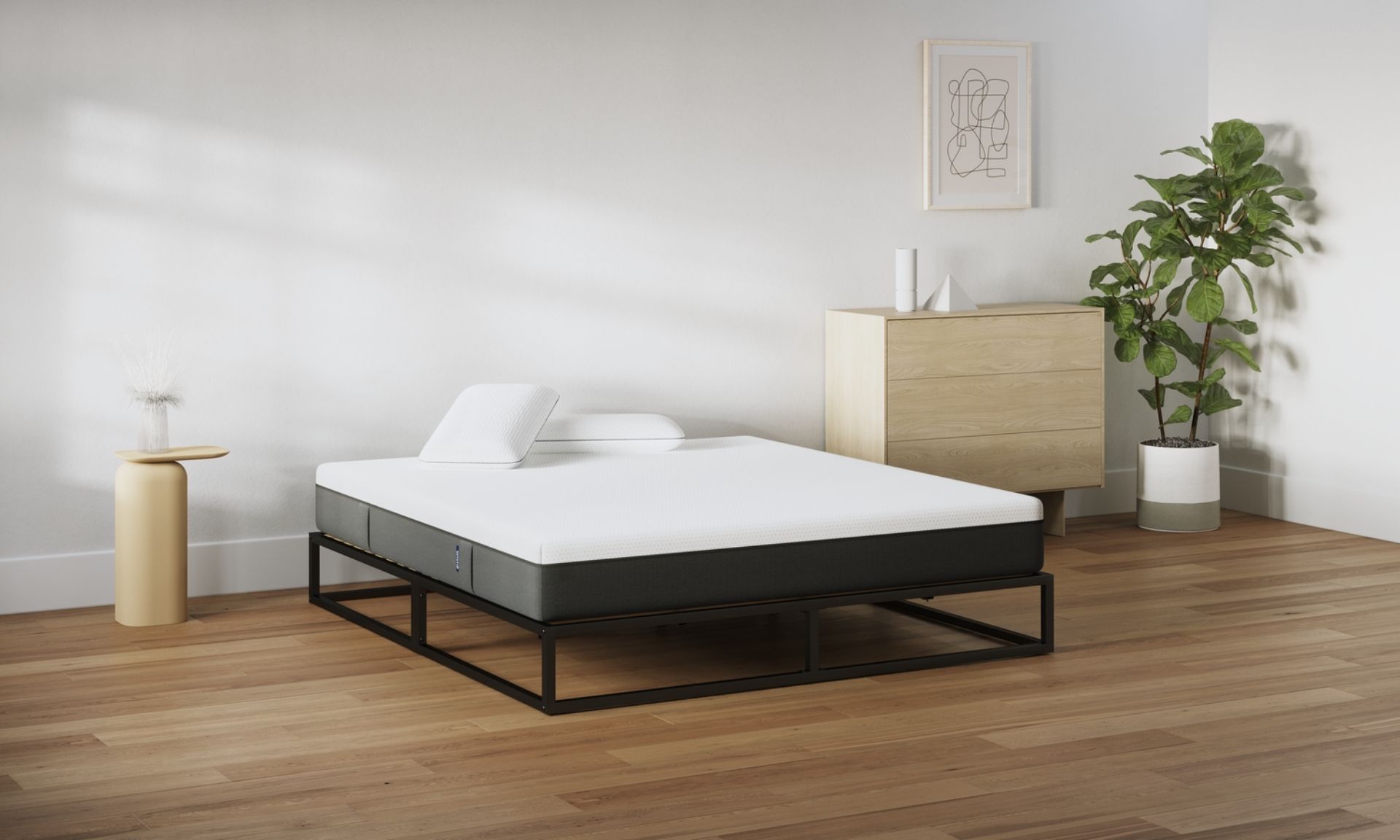 Camera da letto minimal con letto a struttura metallica nera, materasso bianco e due cuscini.