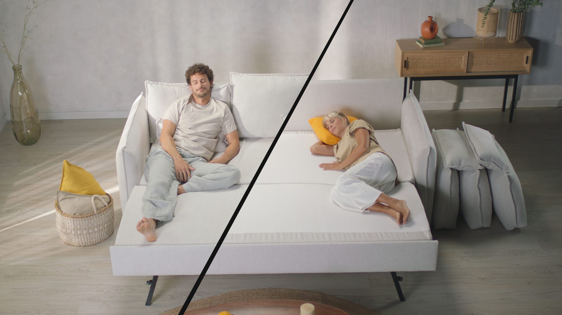 Comparaison en écran partagé d’un canapé convertible blanc : à gauche, un homme assis en position canapé avec coussins de dossier ; à droite, une femme allongée en position lit avec les coussins retirés. Sol en bois clair, panier en osier avec coussin jaune, vase en verre avec branches décoratives et console en bois avec objets déco. Ambiance lumineuse et épurée.