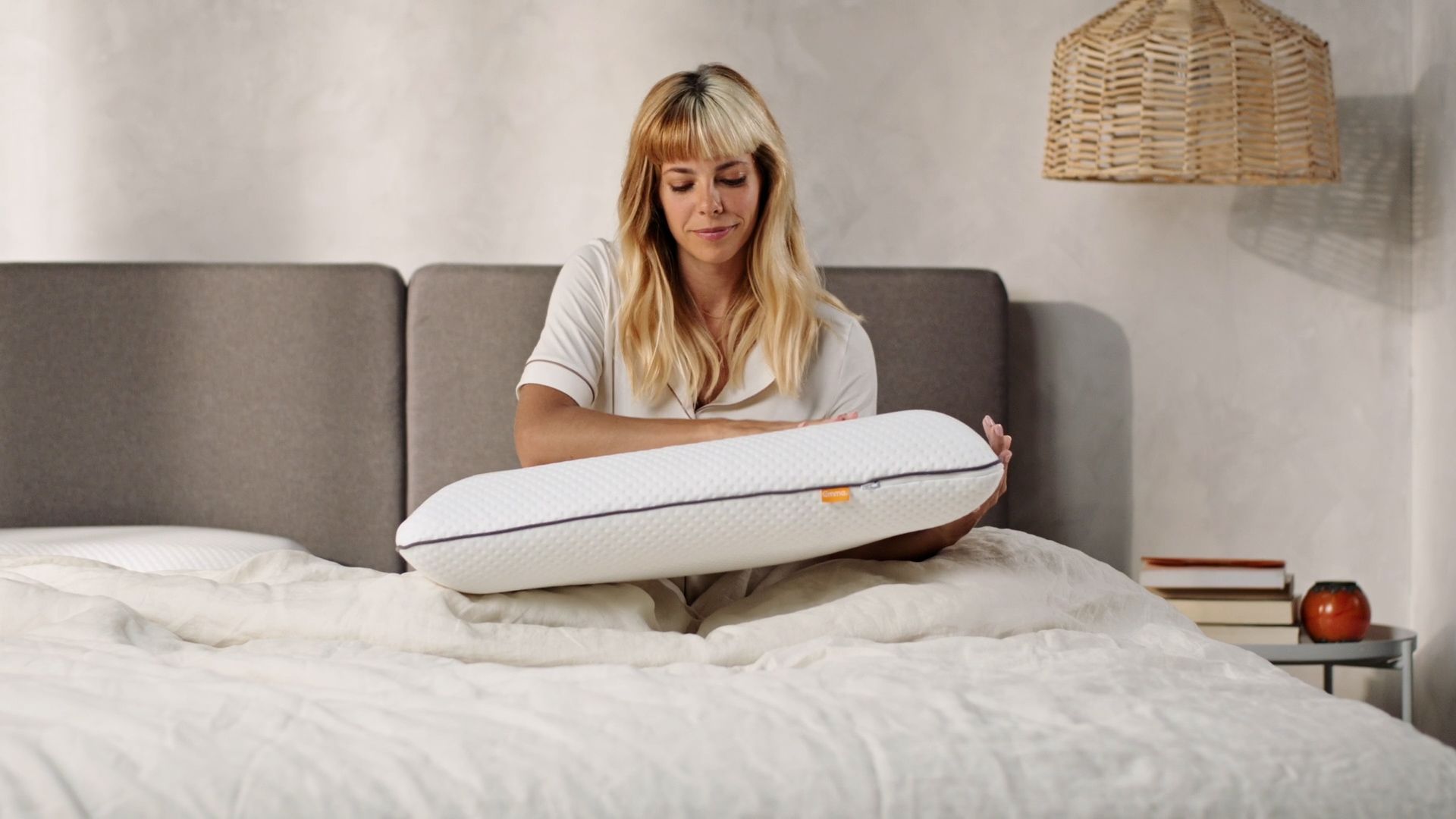 Una chica acariciando la almohada viscoelástica Emma Original.