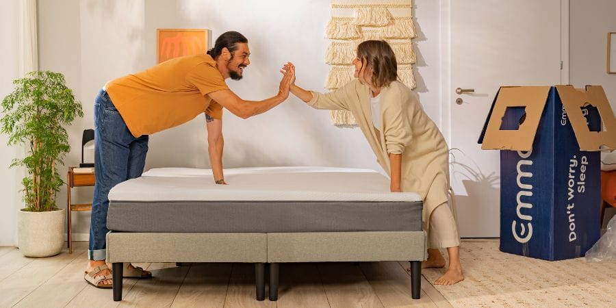 Pareja chocando las manos después de instalar su nuevo colchón Emma
