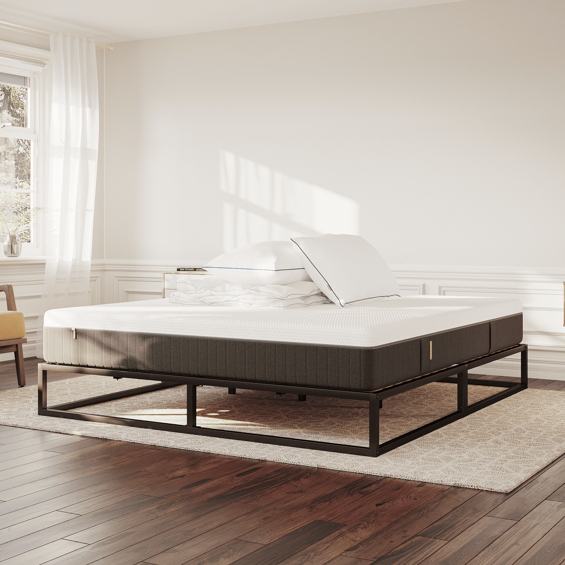Moderne slaapkamer met Emma Urban Deal bed met zwart metalen frame en wit matras, omringd door houten vloer, witte muren, grote ramen, gele fauteuil en decoratieve meubels.