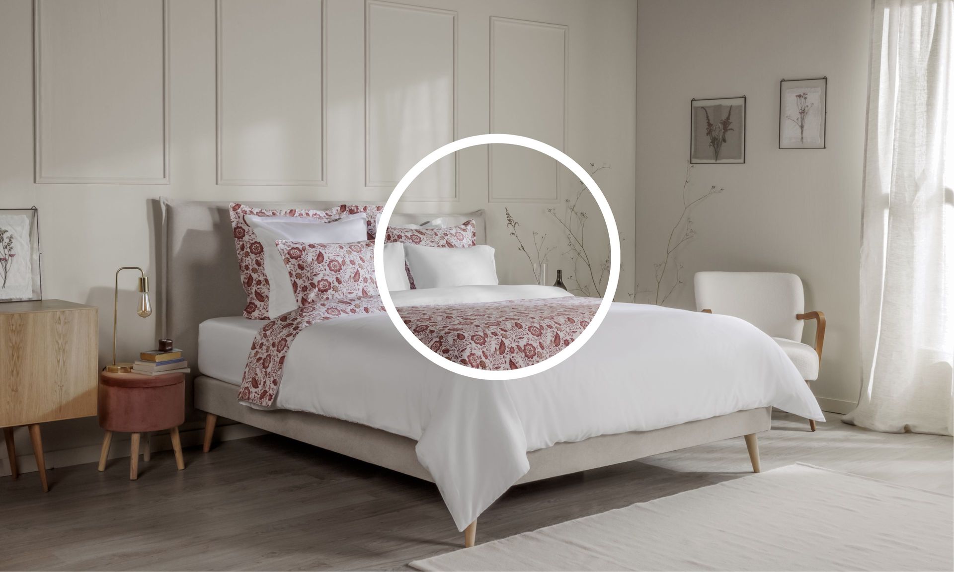 Letto ordinato con biancheria floreale arancione e rosa, in una camera decorata con mobili e quadri.