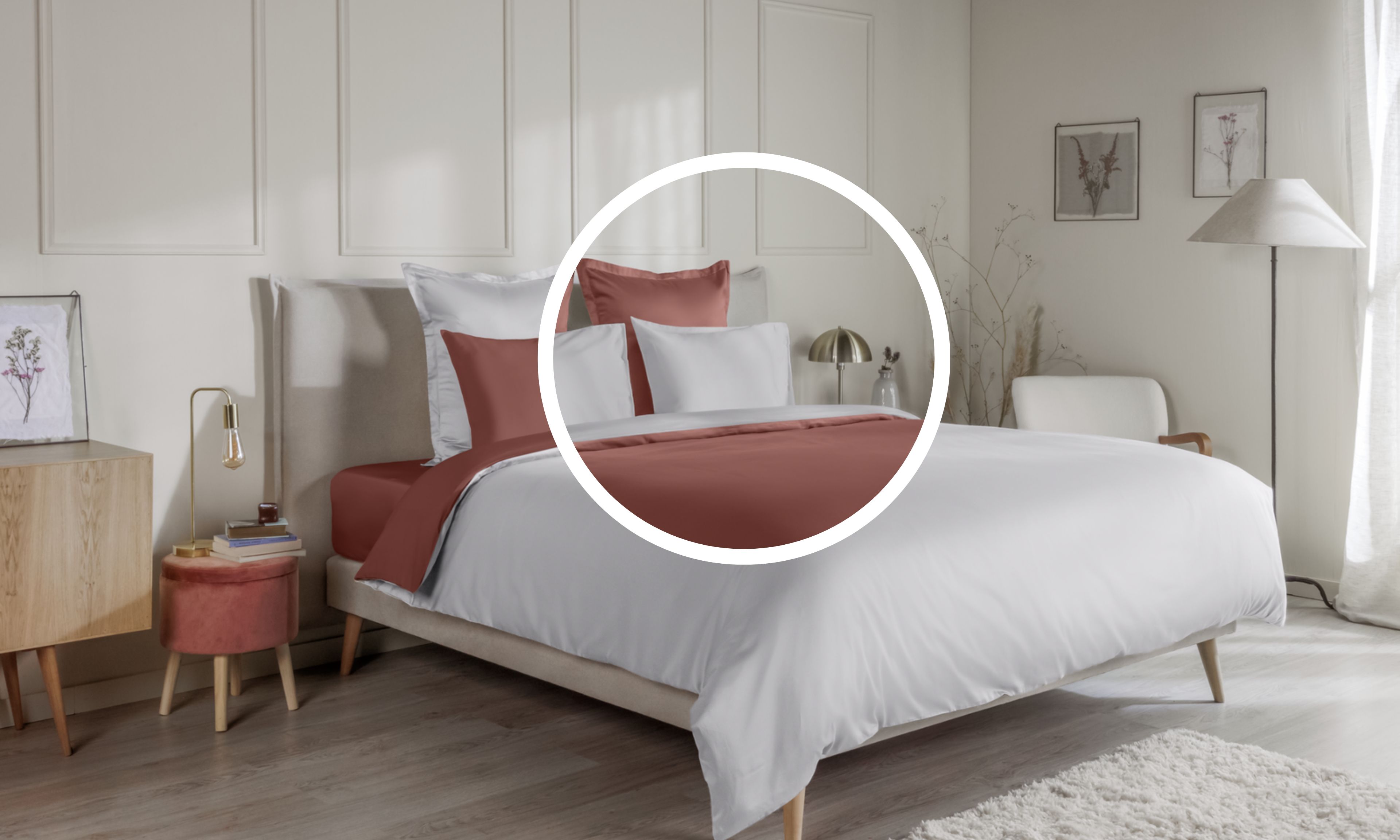 Letto ordinato con biancheria terracotta e bianca , in una camera decorata con mobili e quadri.