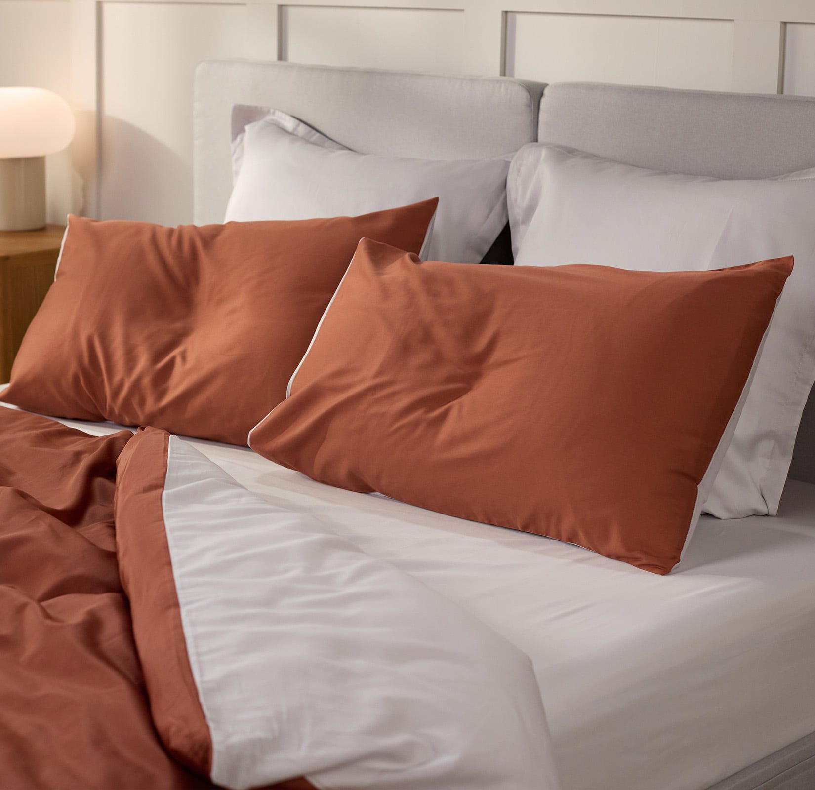 Dekoriertes Schlafzimmer mit Fokus auf dem Bett und passender Bettwäsche