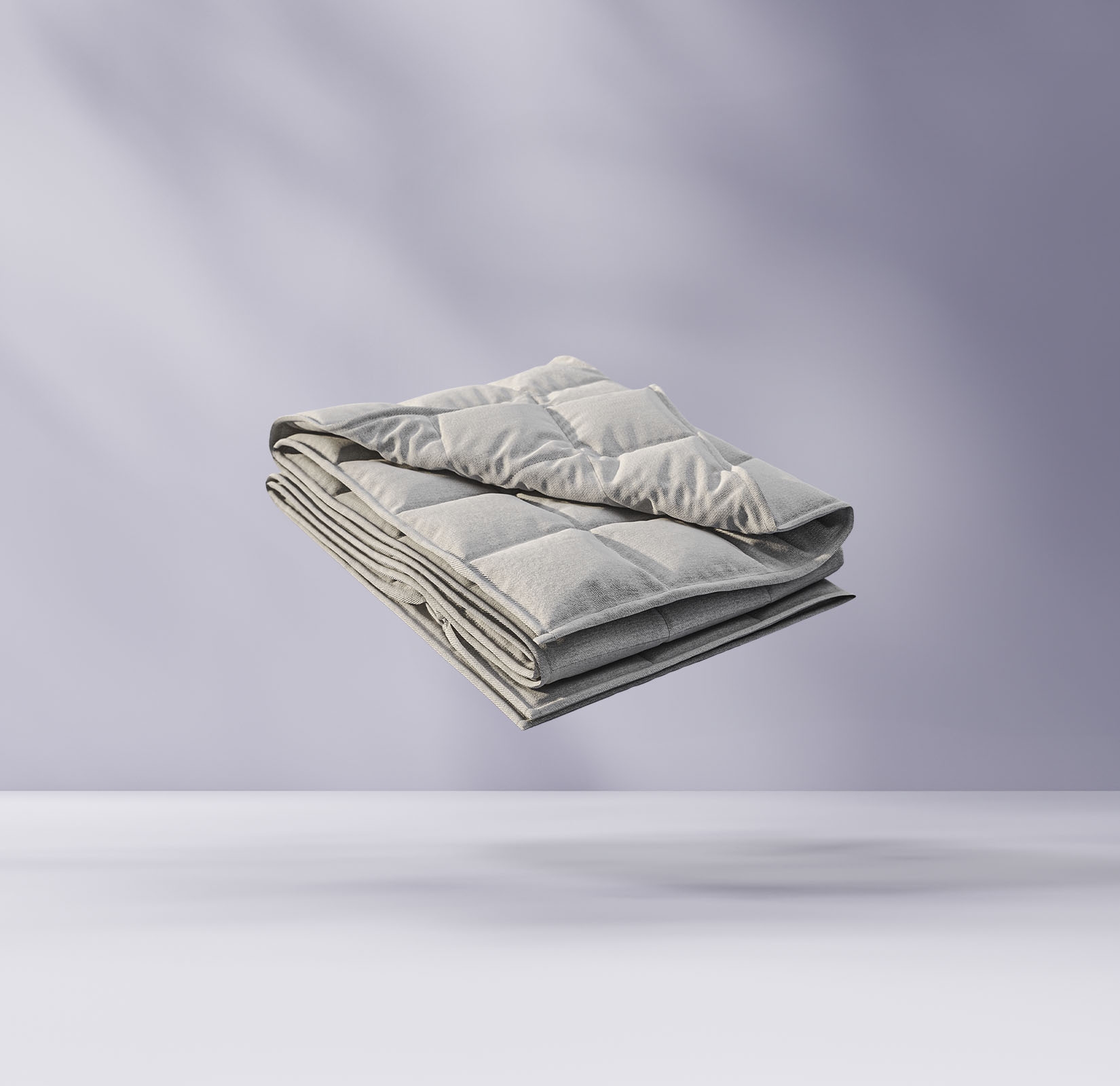 Couette pliée flottant sur un fond violet clair.