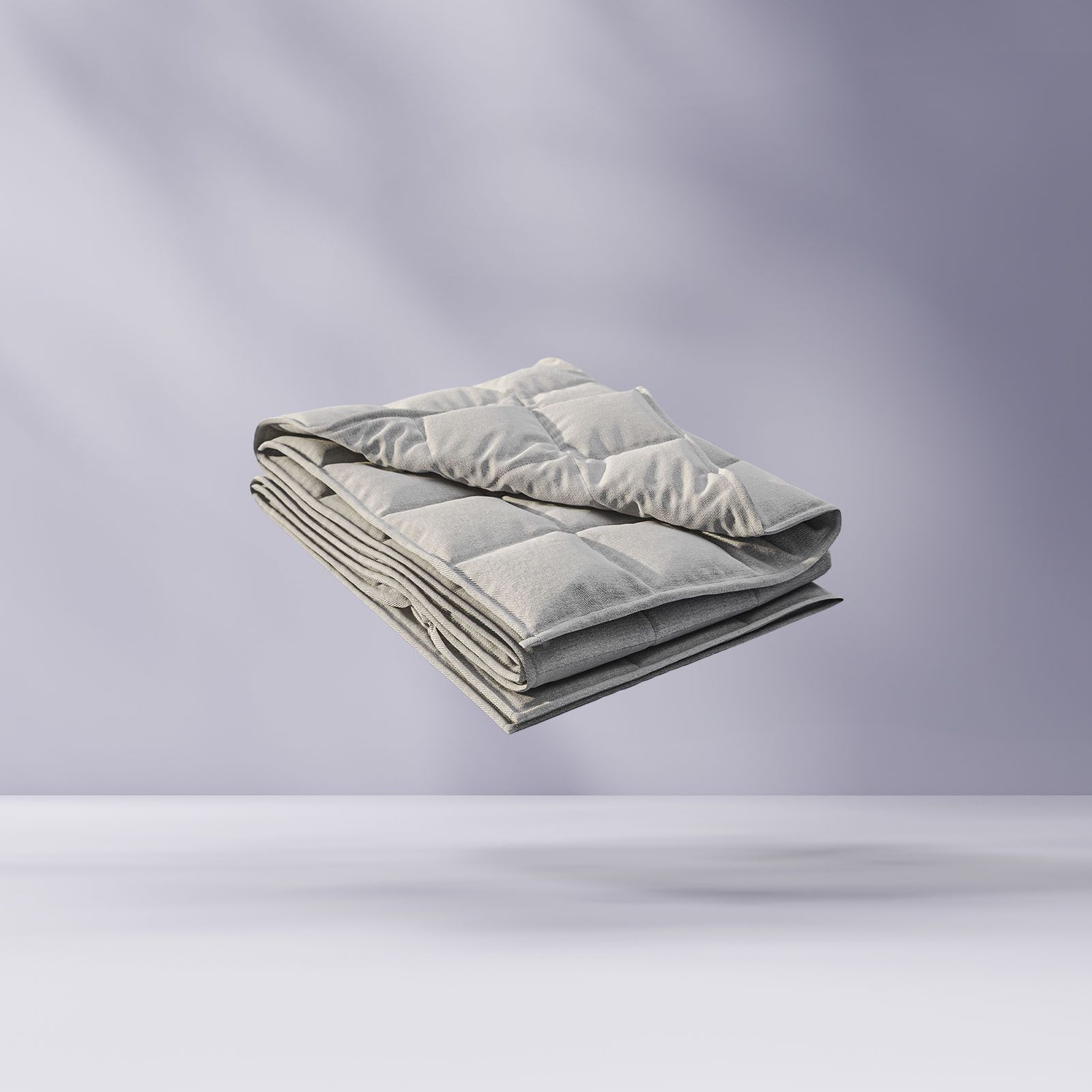 Couette pliée flottant sur un fond violet clair.