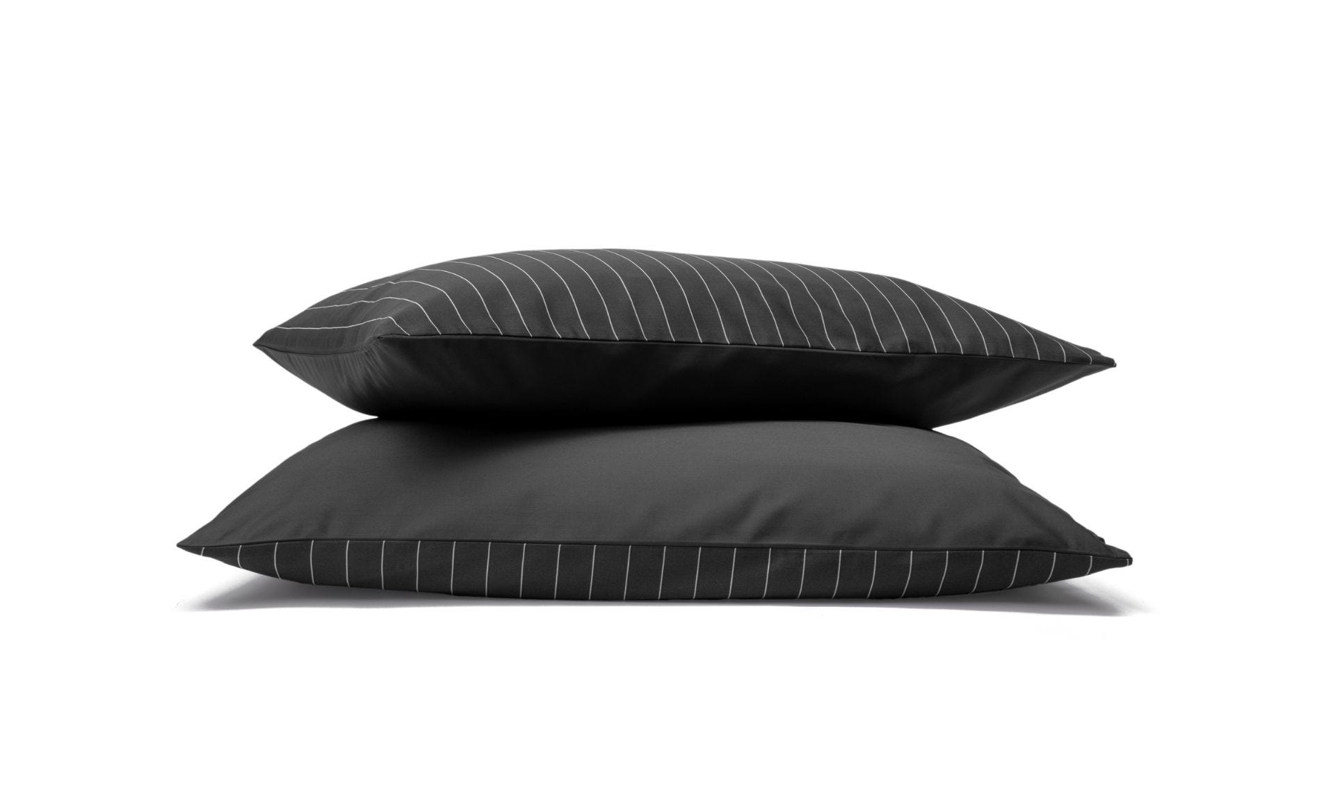 Due federe con righe bianche e base girigio scuro impilate su sfondo bianco.