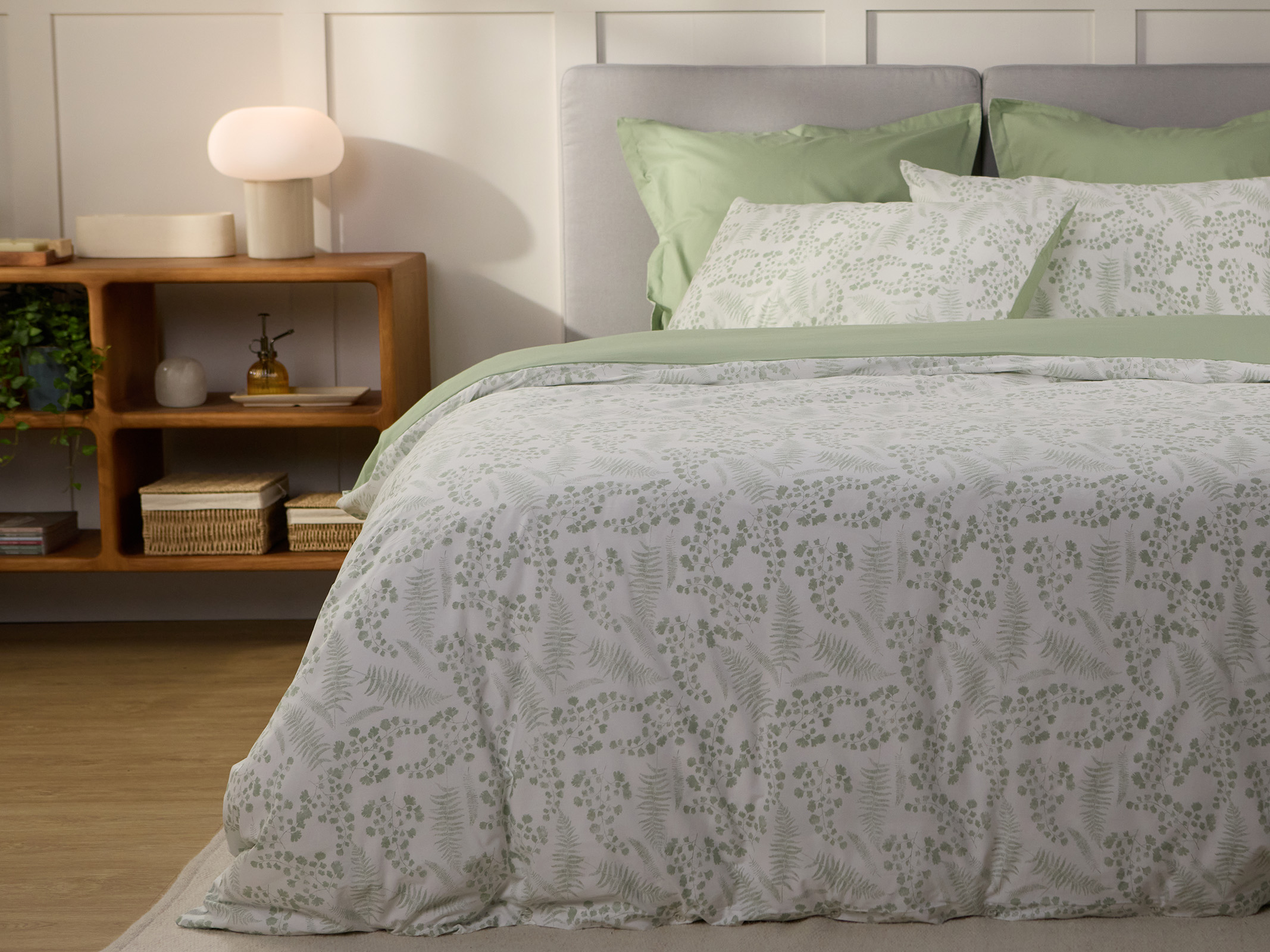 Bed styled with green botanical-print duvet cover and matching pillowcases.