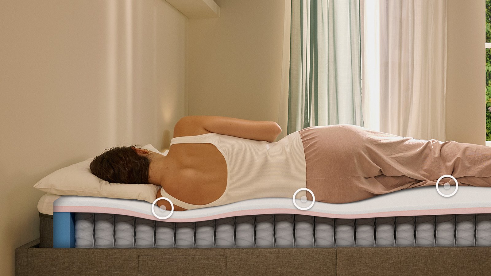 Person lying on their side on a white mattress in a relaxed sleeping position.