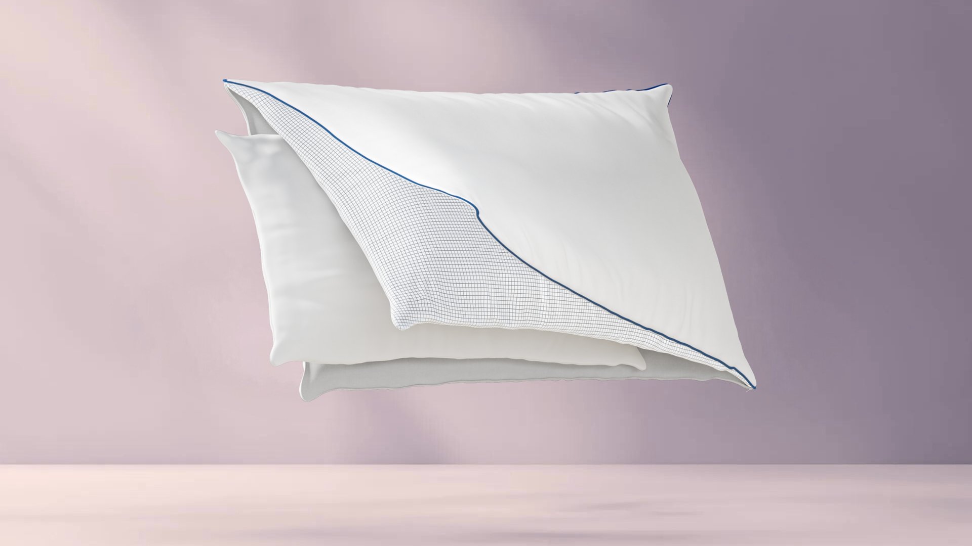 Drie lagen van het Emma Premium Wolkenkussen: witte buitenlaag met blauwe bies, middenlaag met rasterpatroon, en gladde witte binnenlaag; lagen zweven los van elkaar tegen pastelroze achtergrond.
