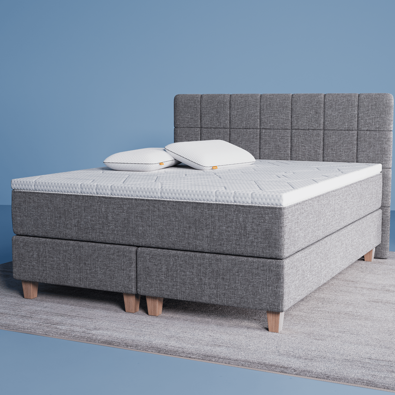 Das original Boxspringbett mit 2 Polster und einer Matratzenauflage in einem Zimmer mit blauen Wänden.