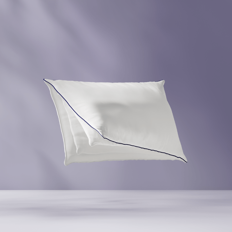 Oreiller flottant montrant ses couches internes. Fond violet clair.