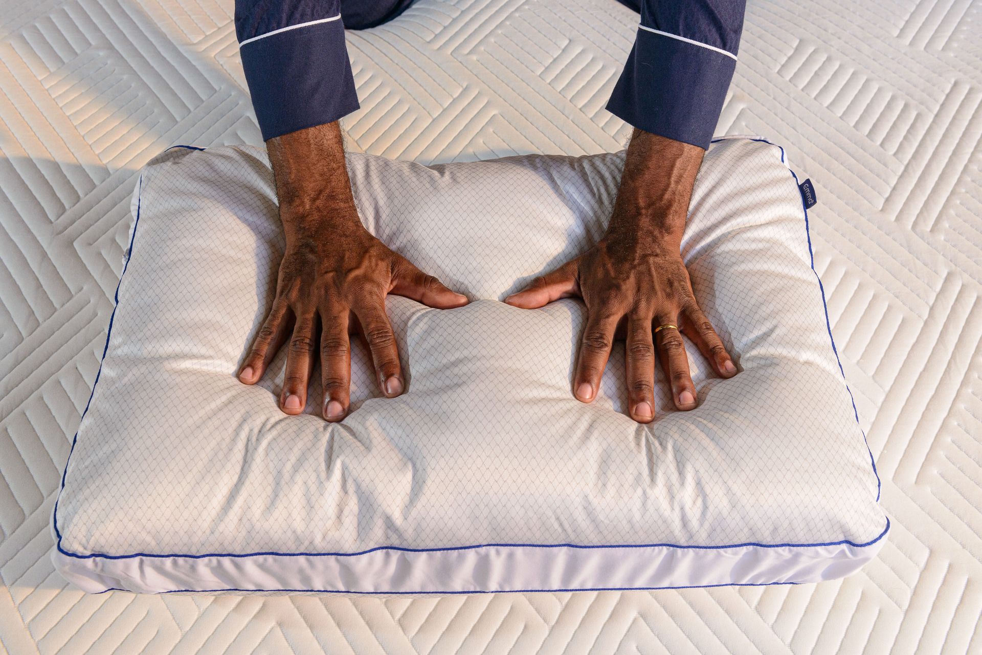 Pessoa a pressionar almofada com as mãos