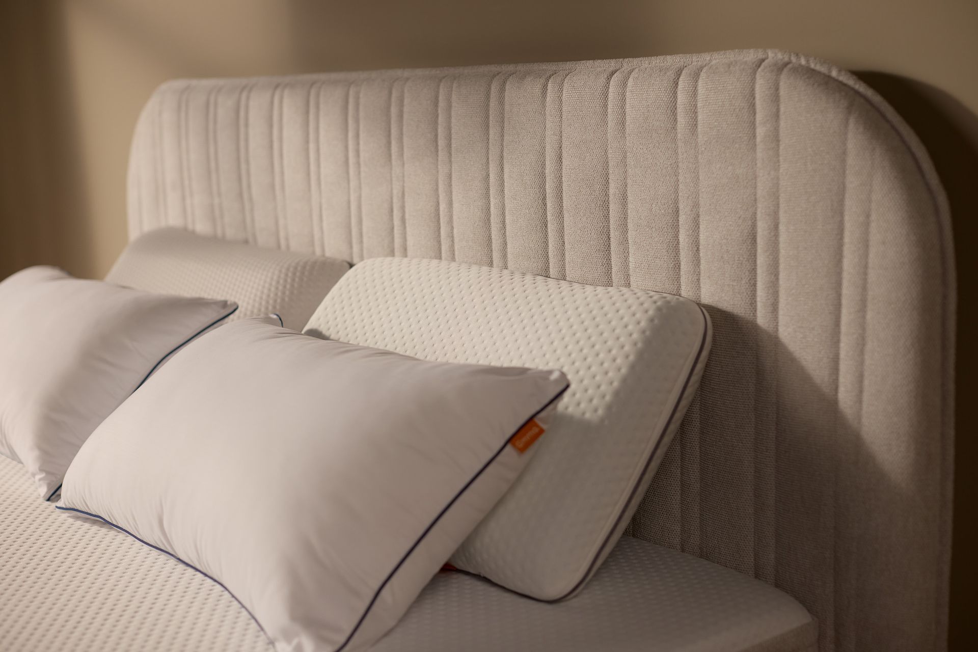 Nahaufnahme des gepolsterten Kopfteils mit vertikaler Kanalsteppung und sauber verarbeiteten Nähten, mit Polster.