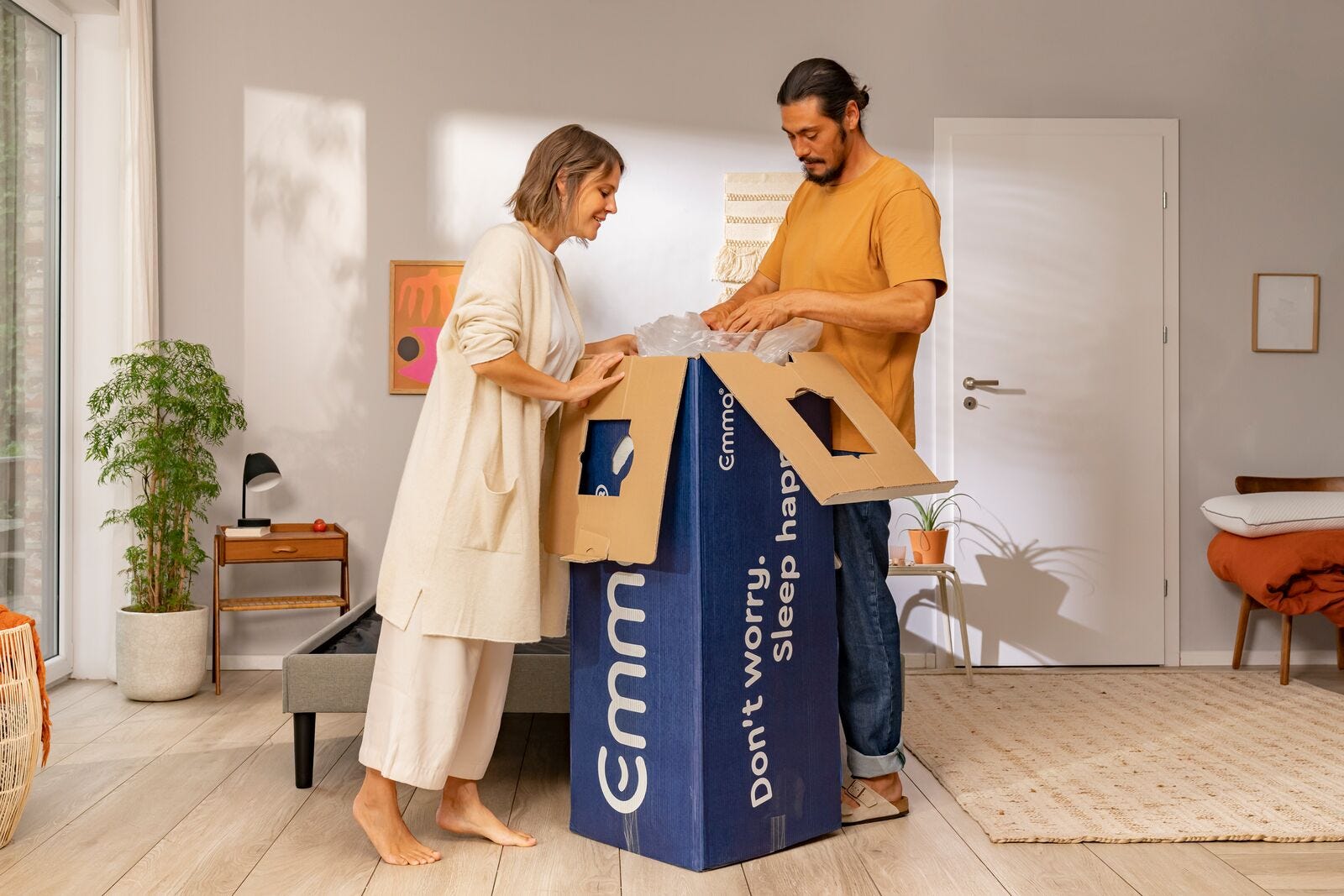 Couple unboxing Emma mattress blue box