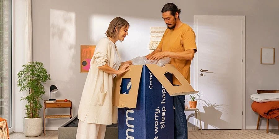 Pareja desembalando su nuevo colchón Emma