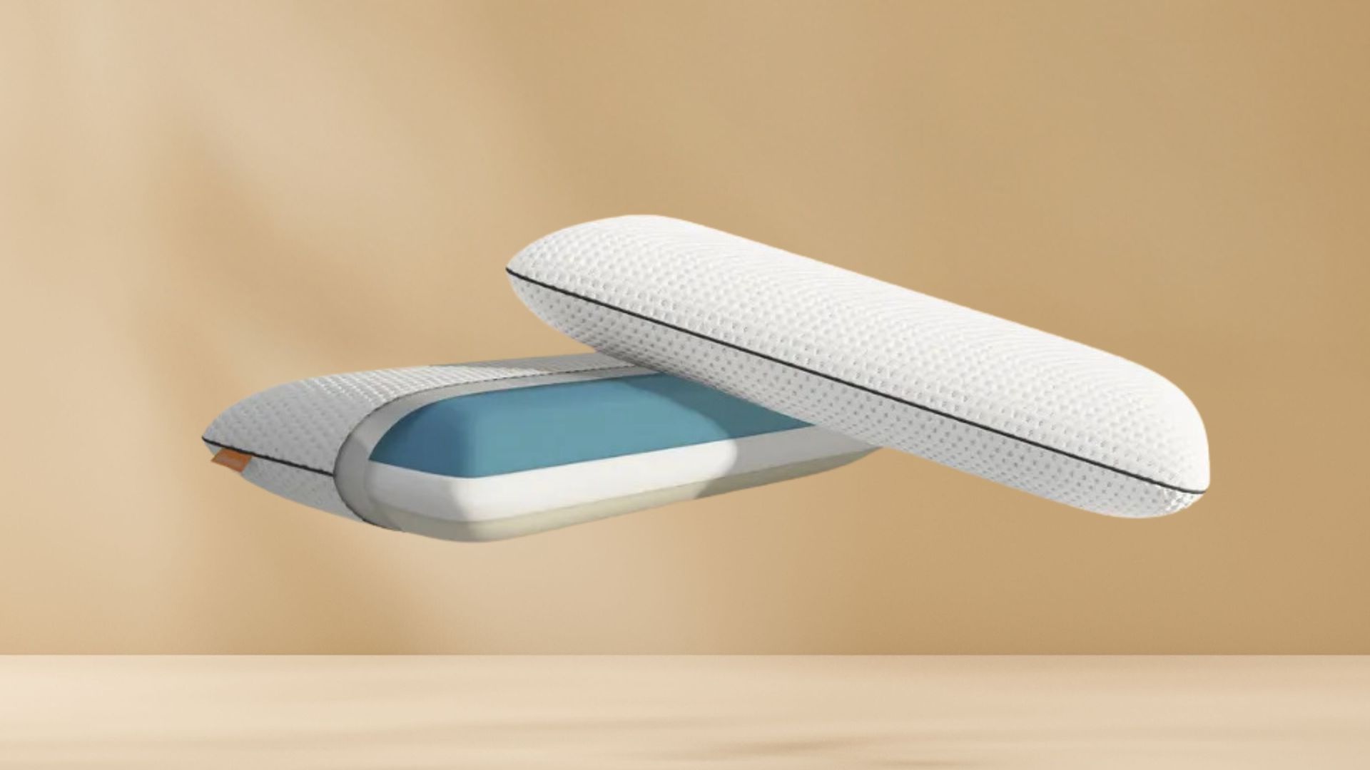 Twee witte Original Adapt Kussens met zwarte rits en blauwe binnenlaag zweven tegen beige achtergrond boven houten ondergrond; één kussen deels geopend, toont binnenstructuur van schuim.