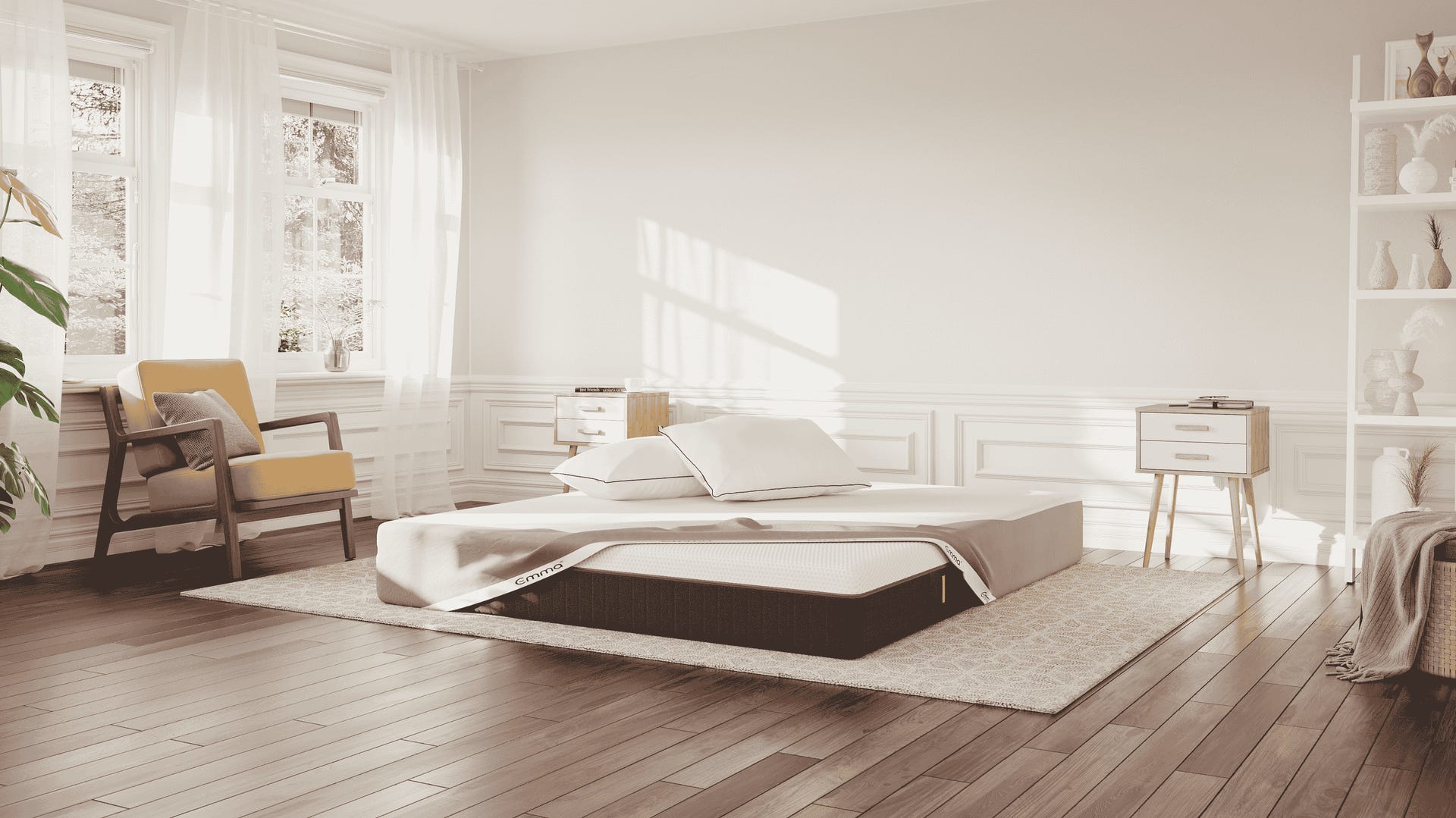 Emma Hybrid Premium Deal: matras op donker vloerkleed in lichte slaapkamer, met Emma matrasbeschermer, twee Wolkenkussens en natuurlijk lichtinval.