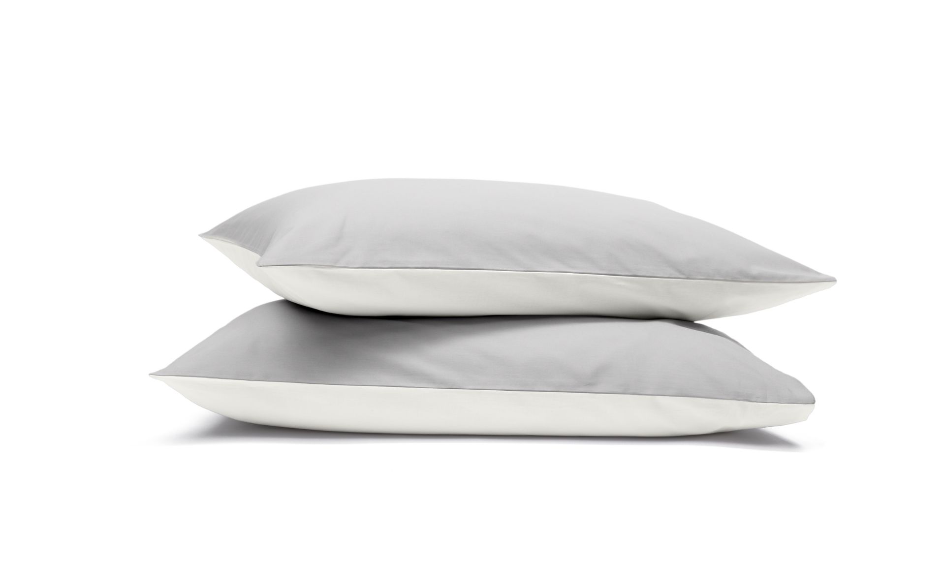 Due federe grigie e bianche impilate su sfondo bianco.