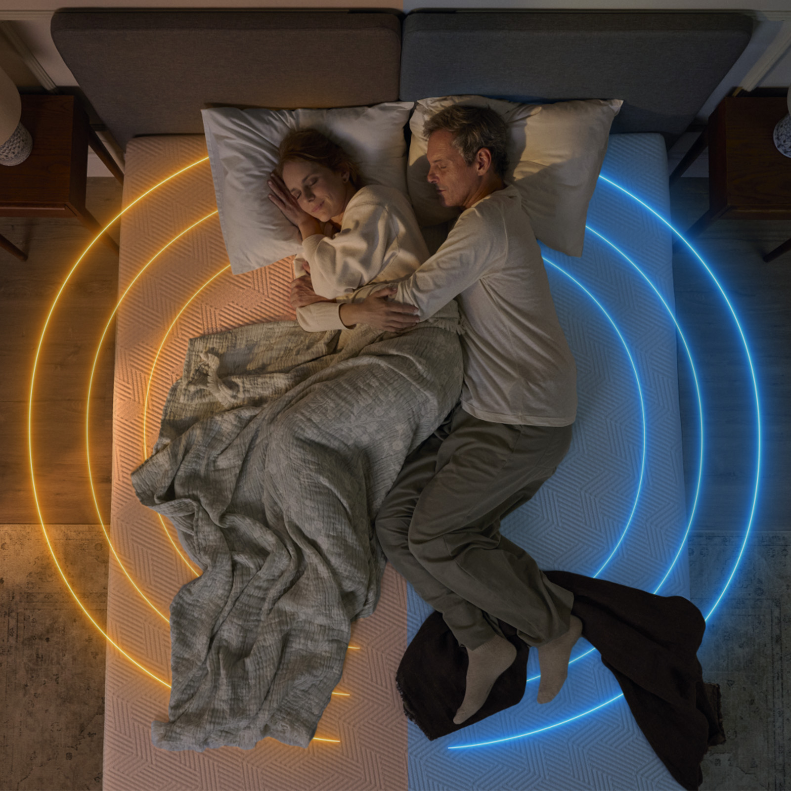 Casal a dormir num colchão com iluminação quente e fria em cada lado.
