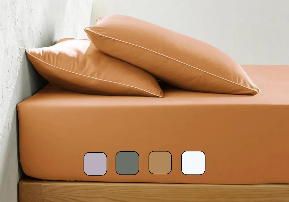 Vue latérale d’un matelas avec drap-housse et oreillers posés dessus.