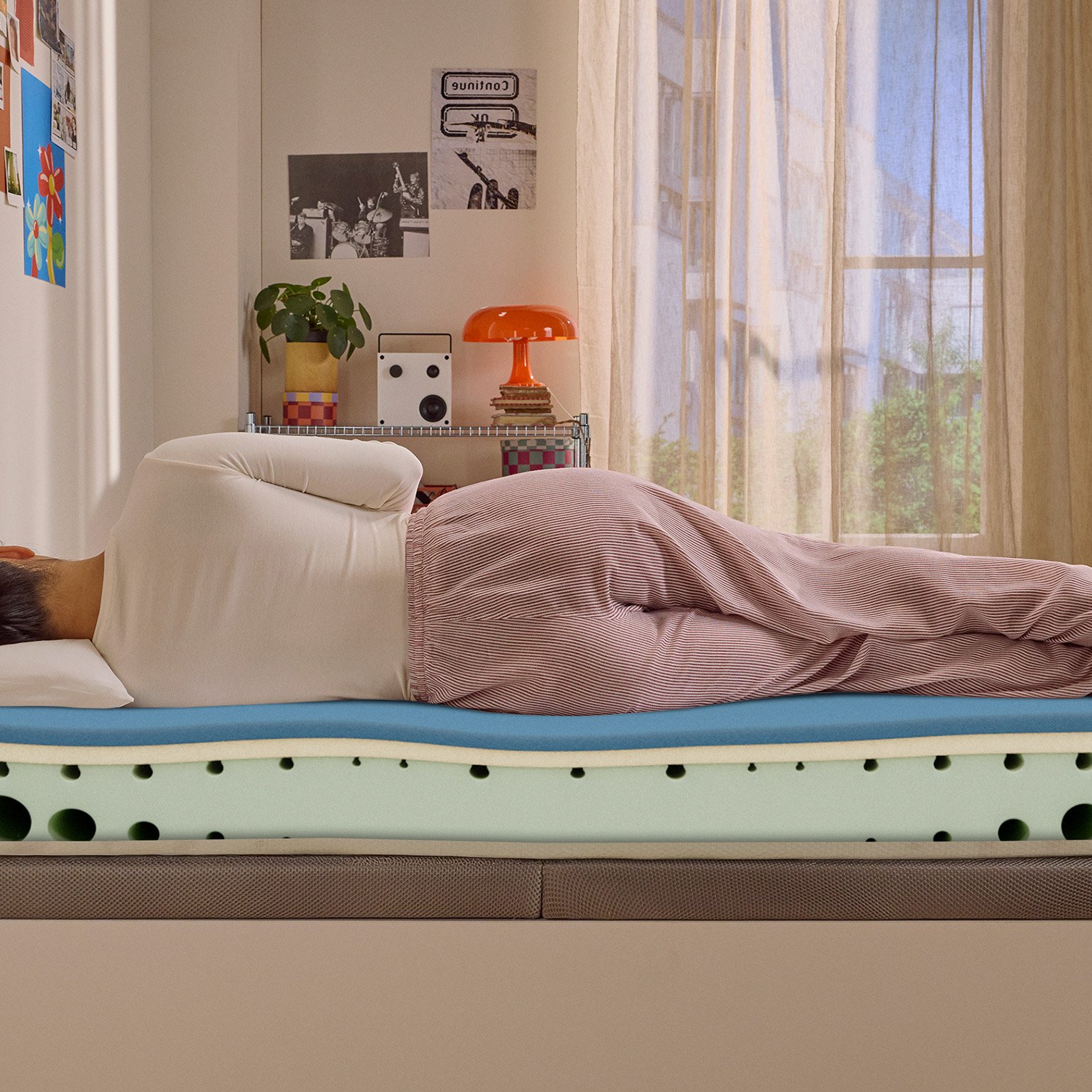 Person lying on their side on a white mattress in a relaxed sleeping position.