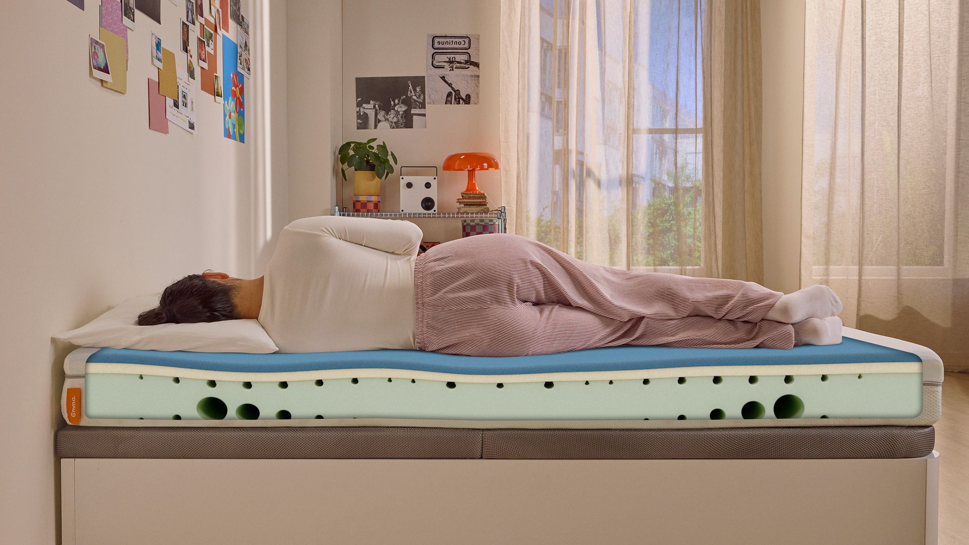 Person lying on their side on a white mattress in a relaxed sleeping position.