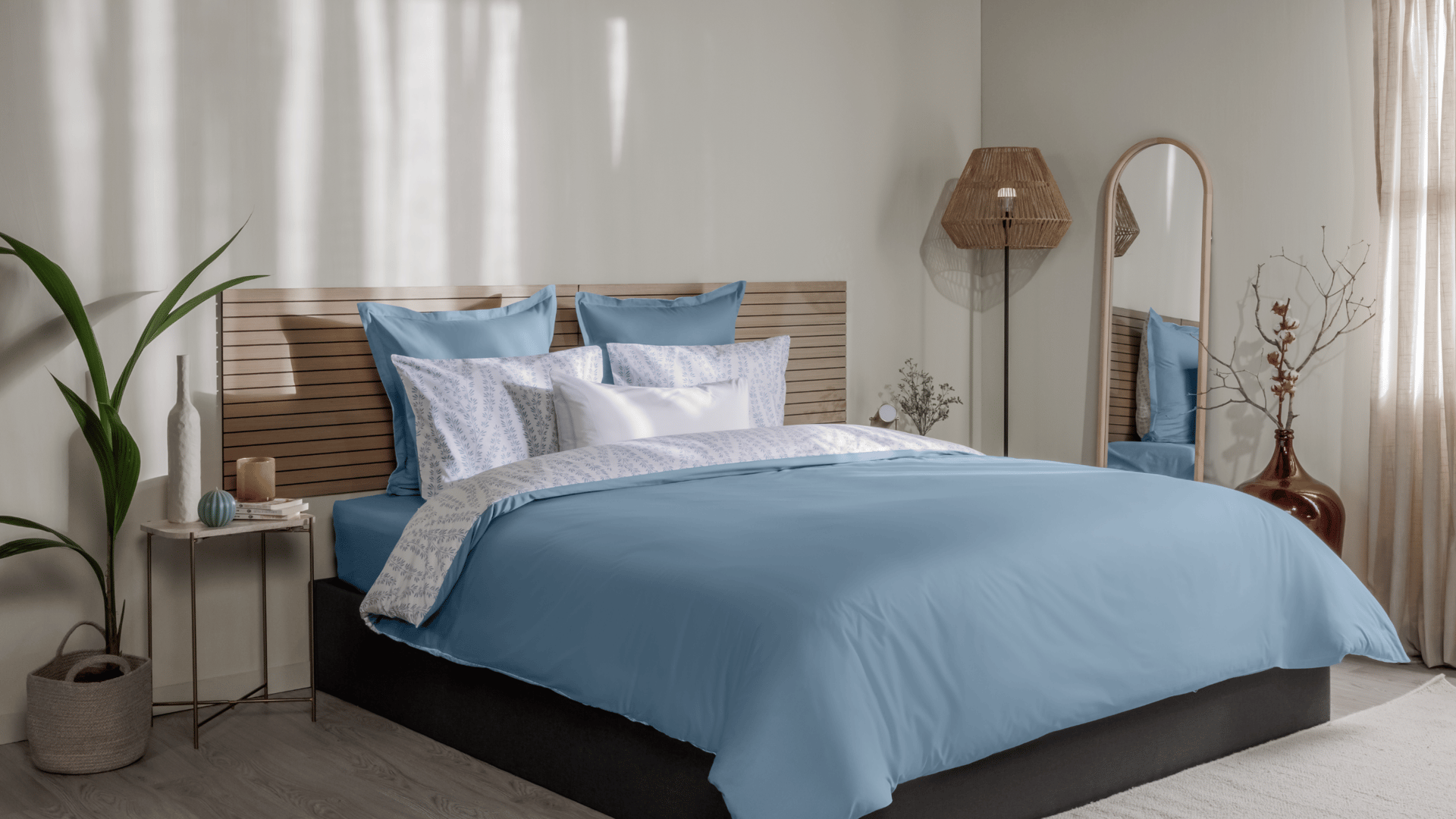 Vue de face d’une chambre décorée, avec un lit doté d’une couette colorée et de taies d’oreiller.