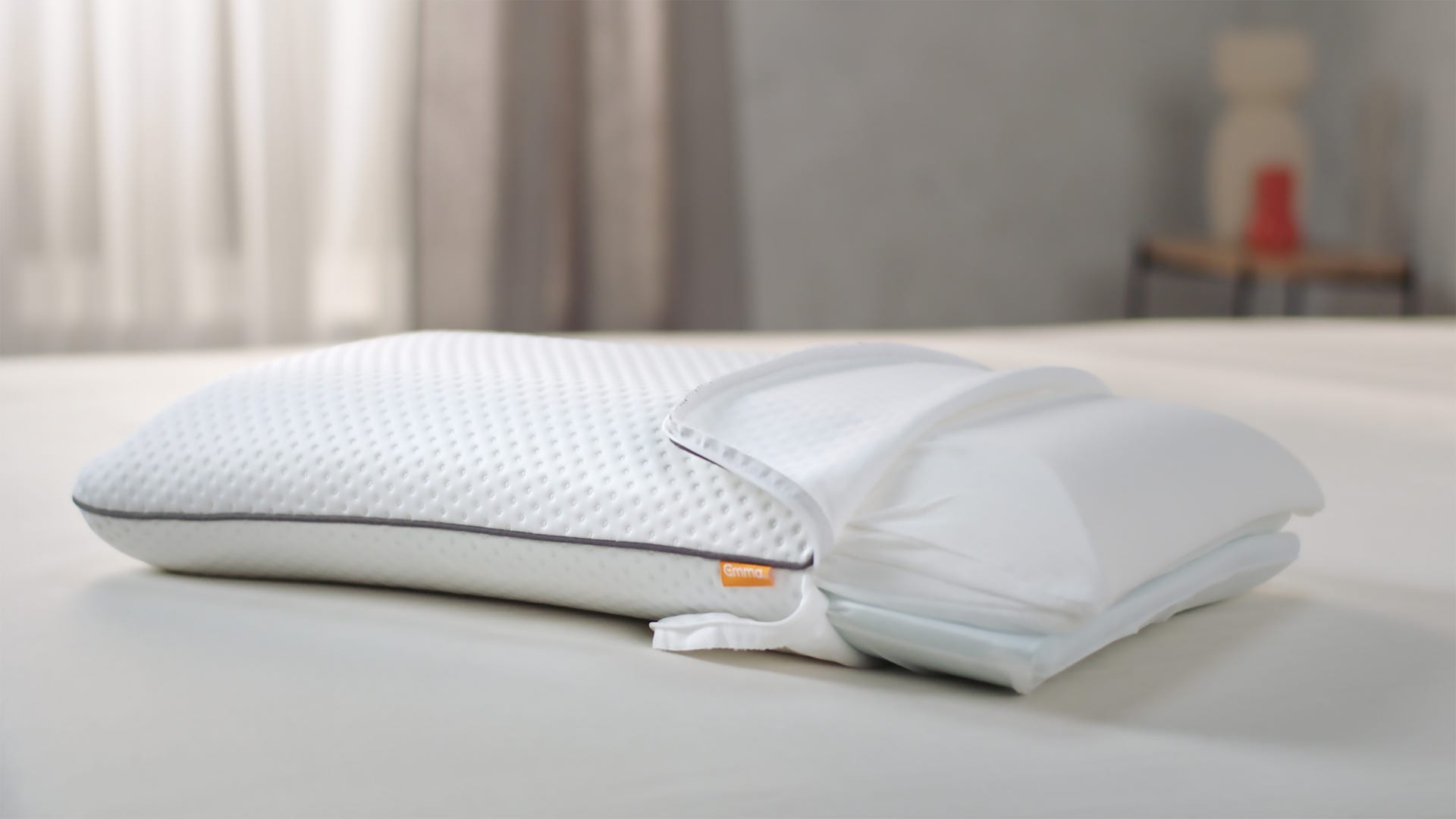Almohada viscoelástica original abierta por capas encima de una cama