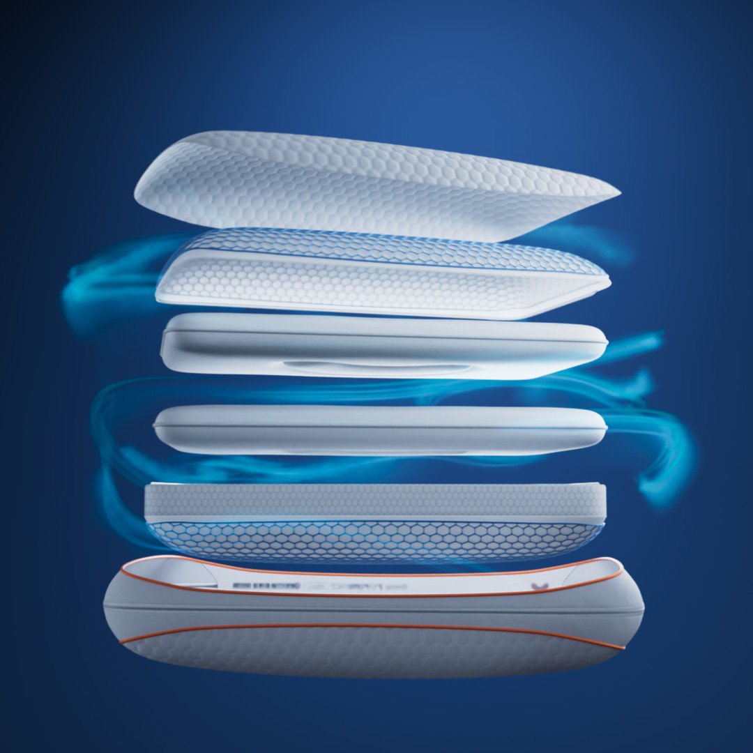 Emma Performance Hybrid Pillow exploded view showing AirGrid, foam layers, and orange-trim base on dark blue background.