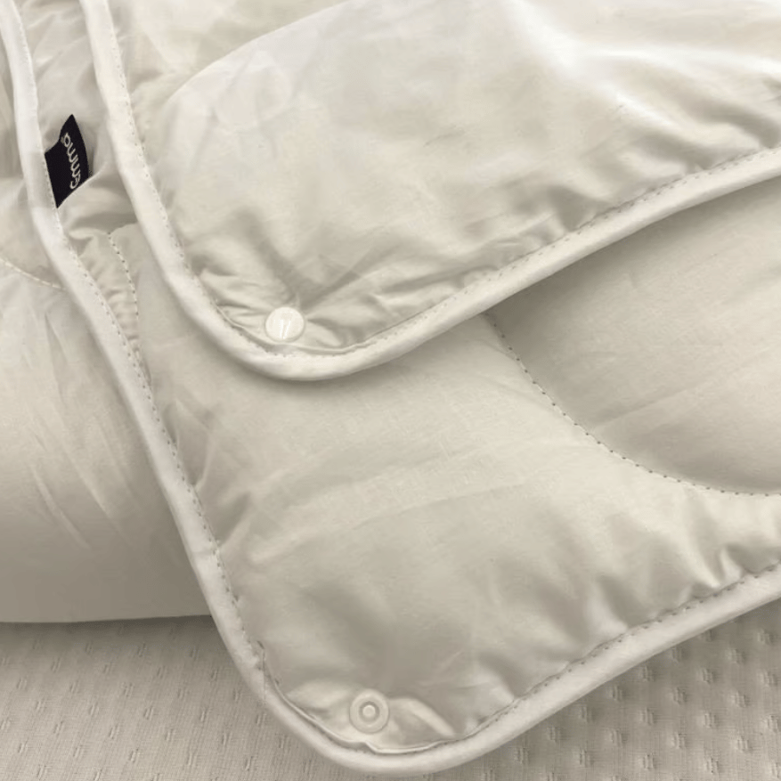 Gros plan des boutons permettant de combiner les couches de la couette, avec un logo Emma.