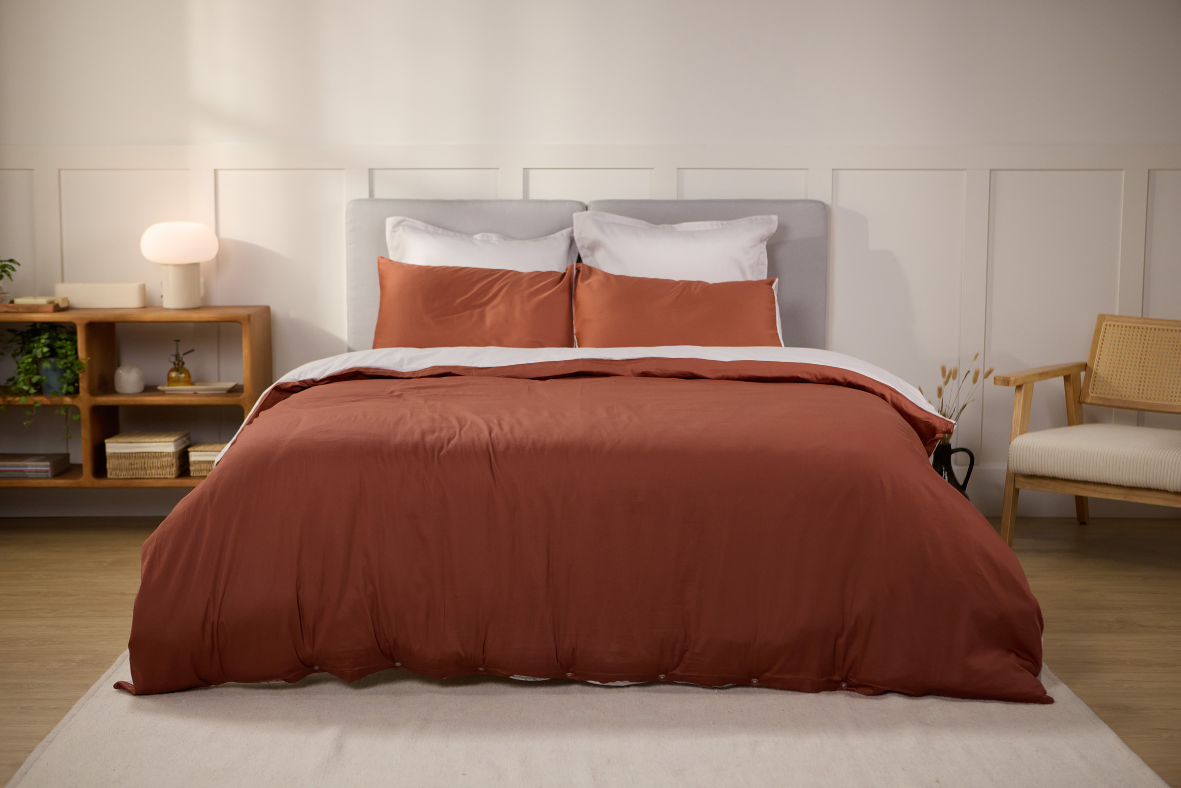 Bett mit weißer Bettdecke und Kissen.