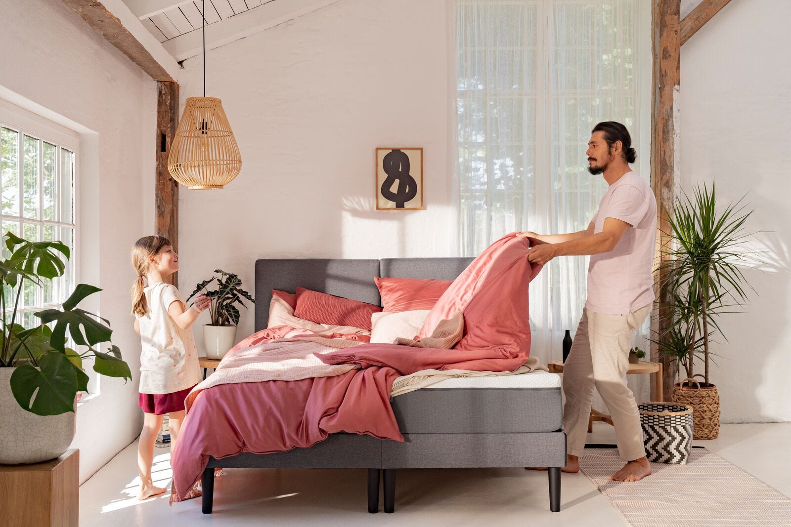 Dad making bed with daughter mood picture pink bed linen 