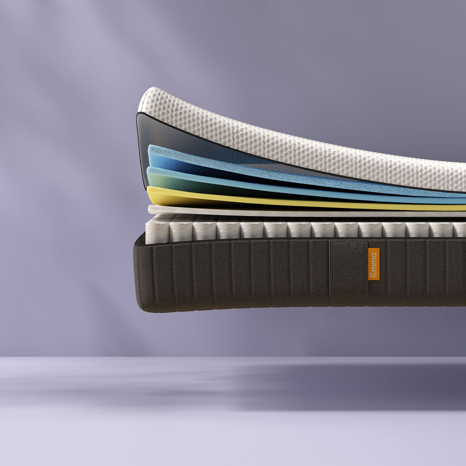Une vue en coupe d'un matelas montre plusieurs couches de mousse colorée empilées au-dessus d'un sommier à ressorts, avec une couche supérieure blanche matelassée. Le matelas est doté d'un panneau latéral en tissu portant une étiquette Emma orange. Le fond est violet clair.