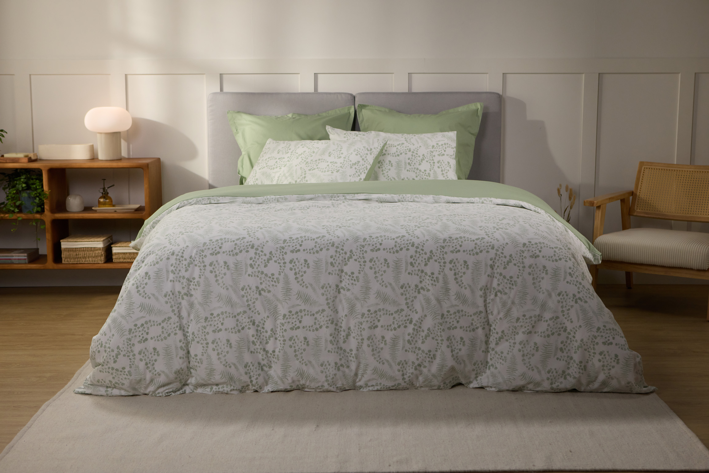 Vue de face d’une chambre décorée, avec un lit doté d’une couette colorée et de taies d’oreiller.