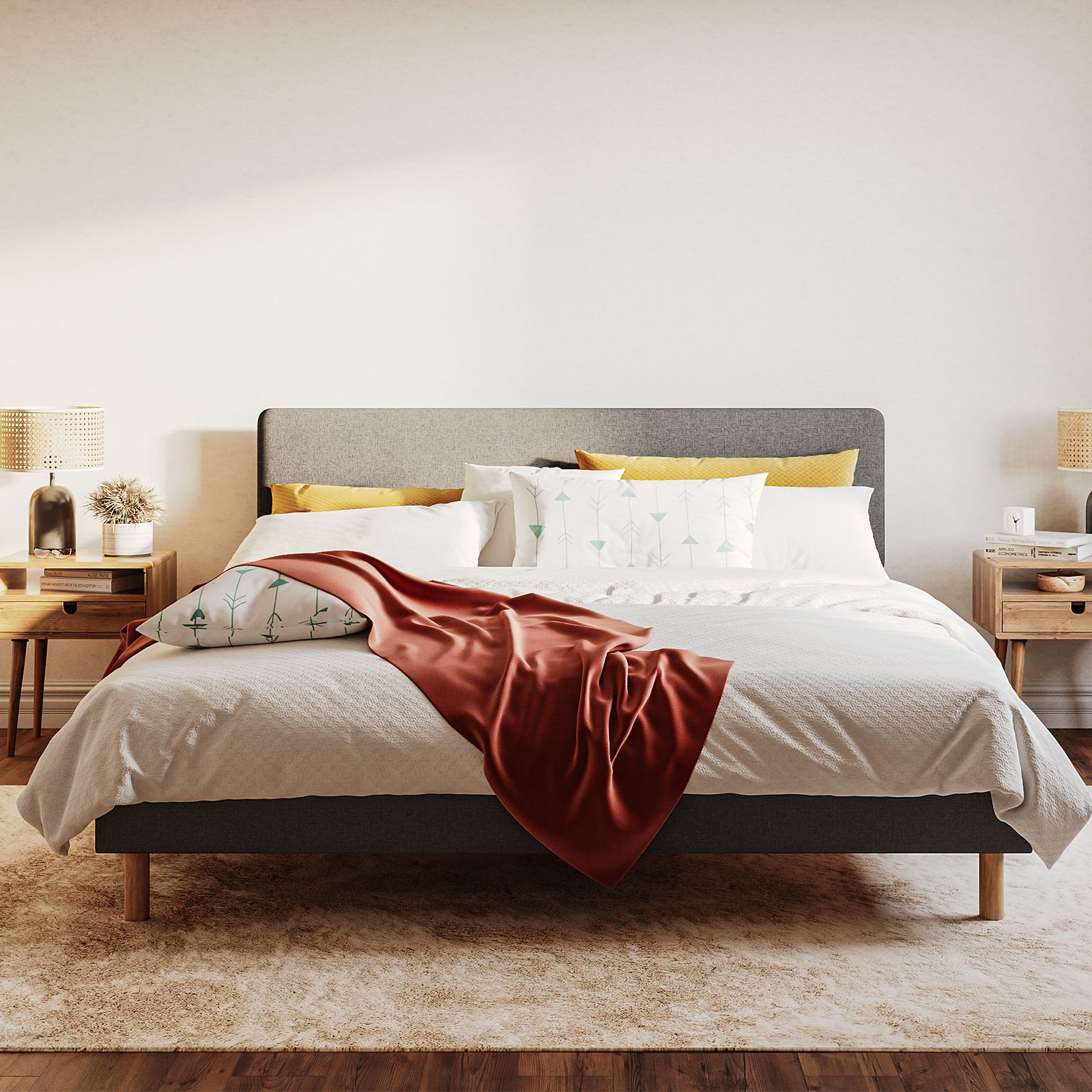 Emma Boxbed in grey with upholstered headboard and wooden legs, styled in a warm Scandinavian bedroom.