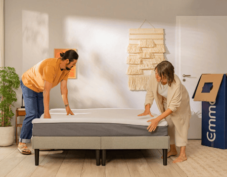 Couple assembling a bed with the mattress