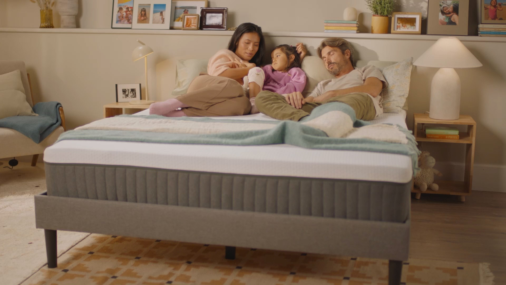 Famille allongée sur un lit dans une chambre douce et lumineuse, illustrant le confort et la stabilité d’un matelas moderne au design premium, entourée d’une décoration chaleureuse et apaisante.